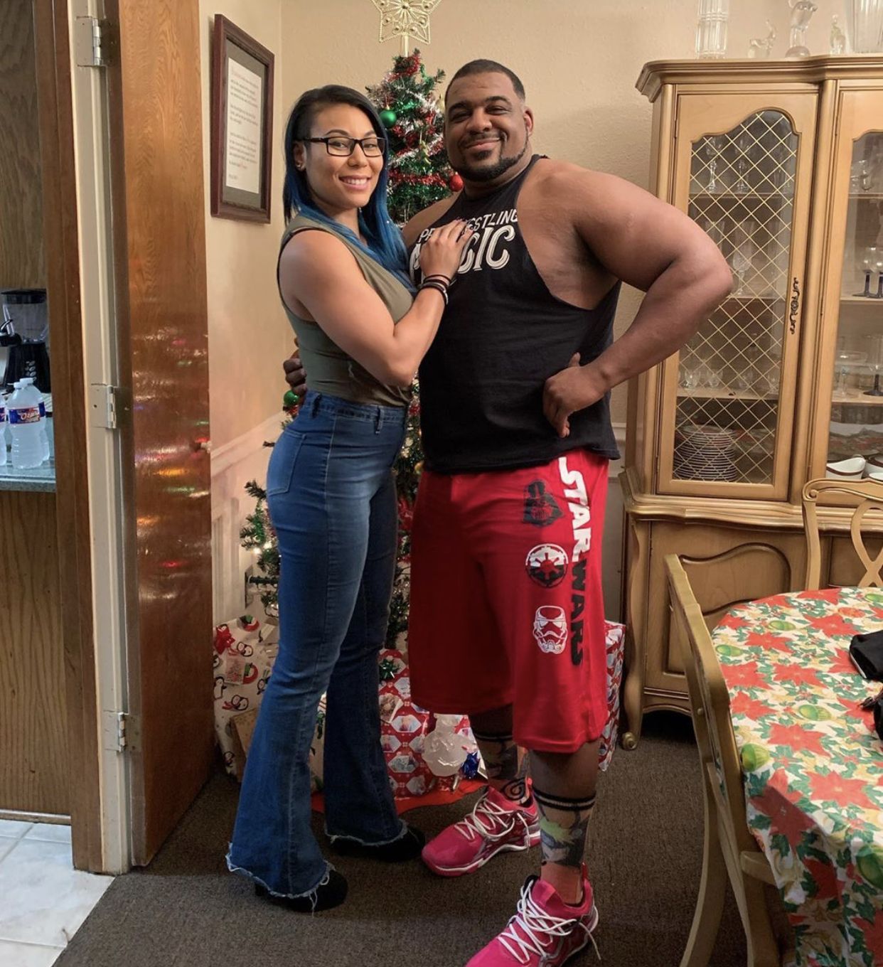 WWE NXT star Mia Yim (Stephanie Yim Bell) and her partner Keith Lee posing in front of their Christmas tree. #WWE #NXT #wwecouples #wwewives #wwewags #wr