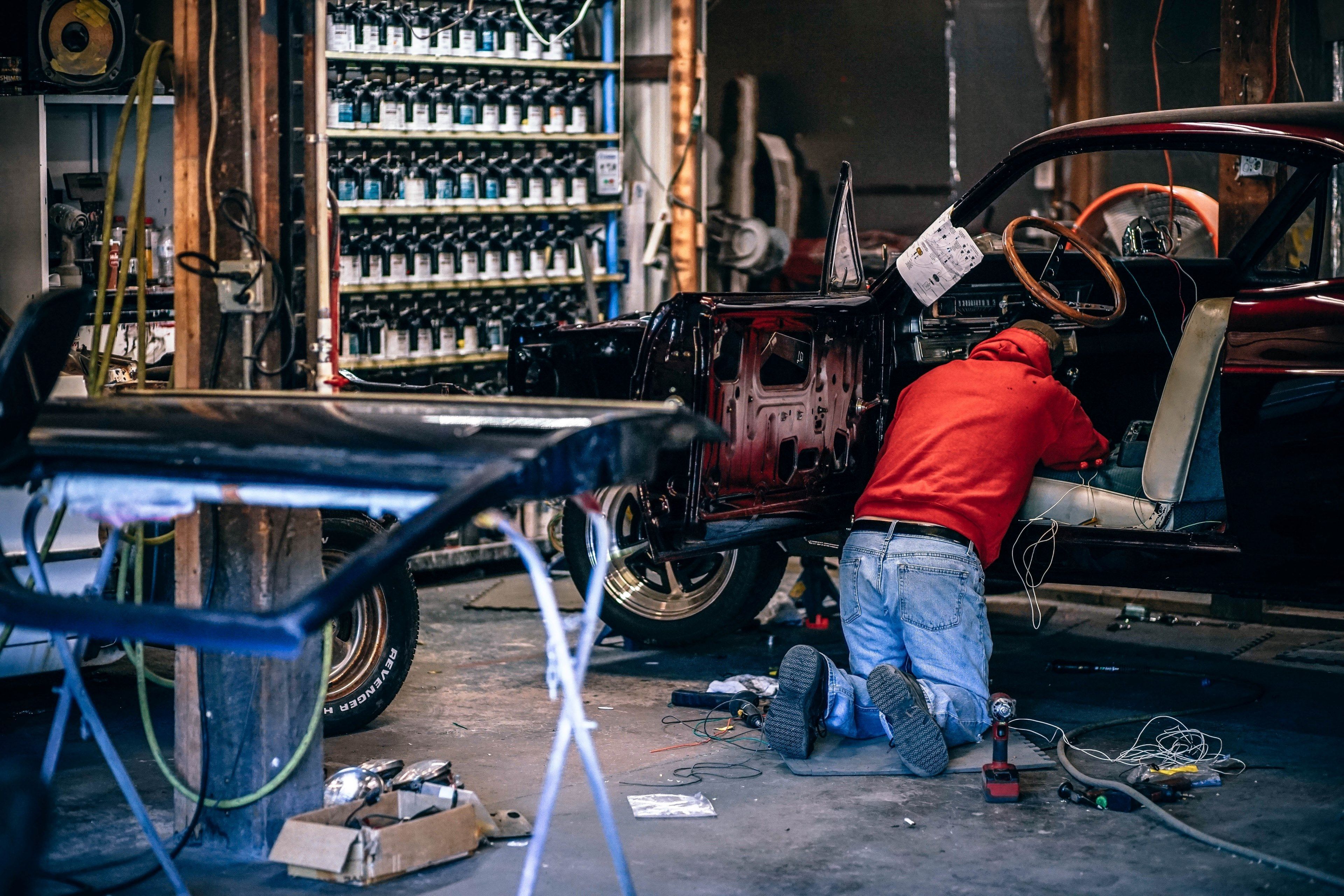 Wallpaper / a car mechanic working on an old car in a workshop, car restoration workshop 4k wallpaper free download