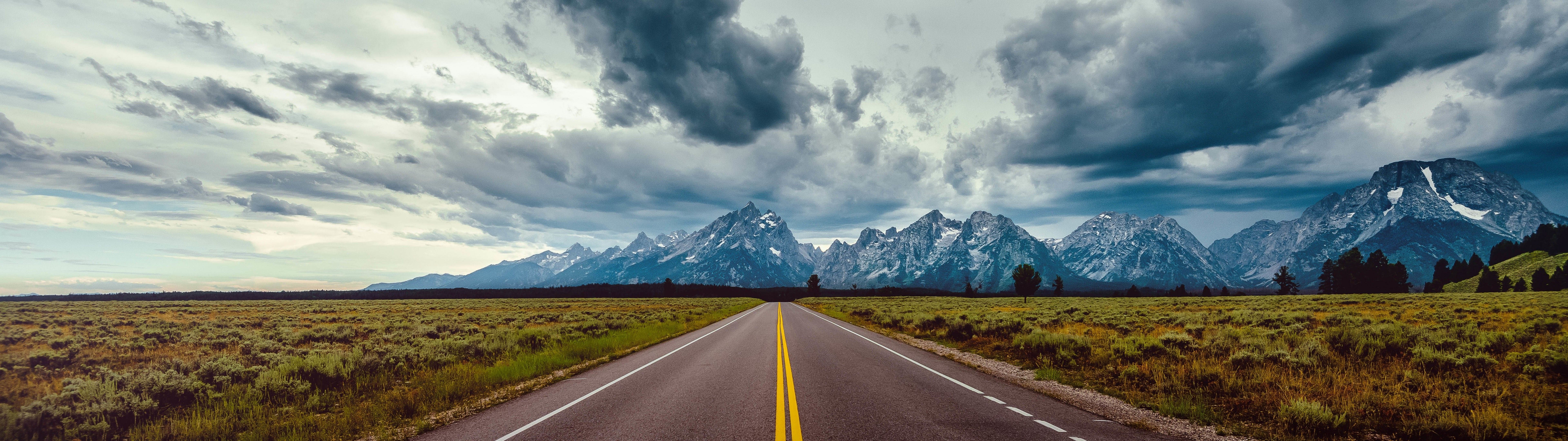 Download 7680x2160 Long Road, Mountains, Dark Clouds, Scenic Wallpaper
