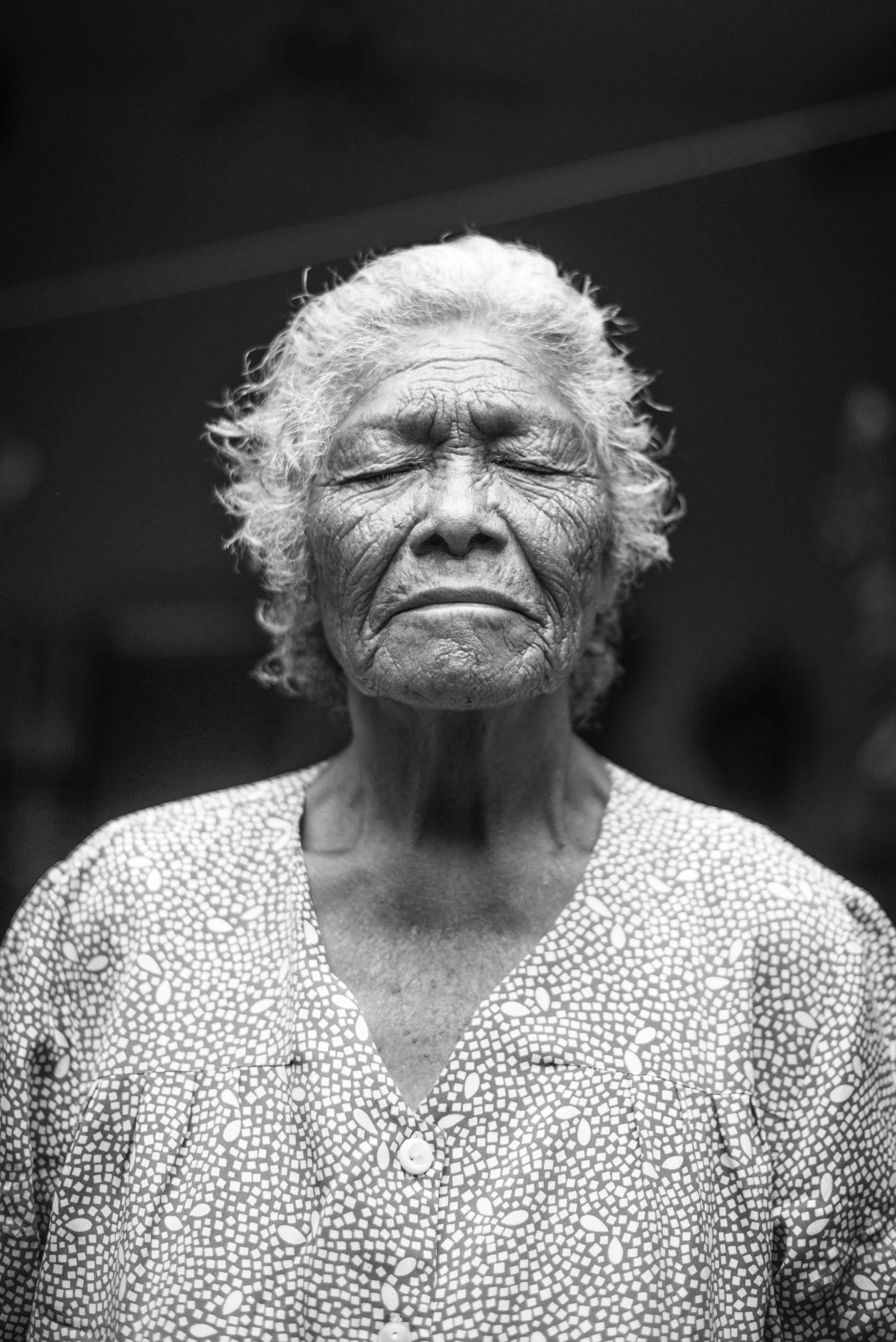 Wallpaper / old grandmother with gray hair and a wrinkled face closing her eyes in black and white, _old woman closing her eyes 4k wallpaper