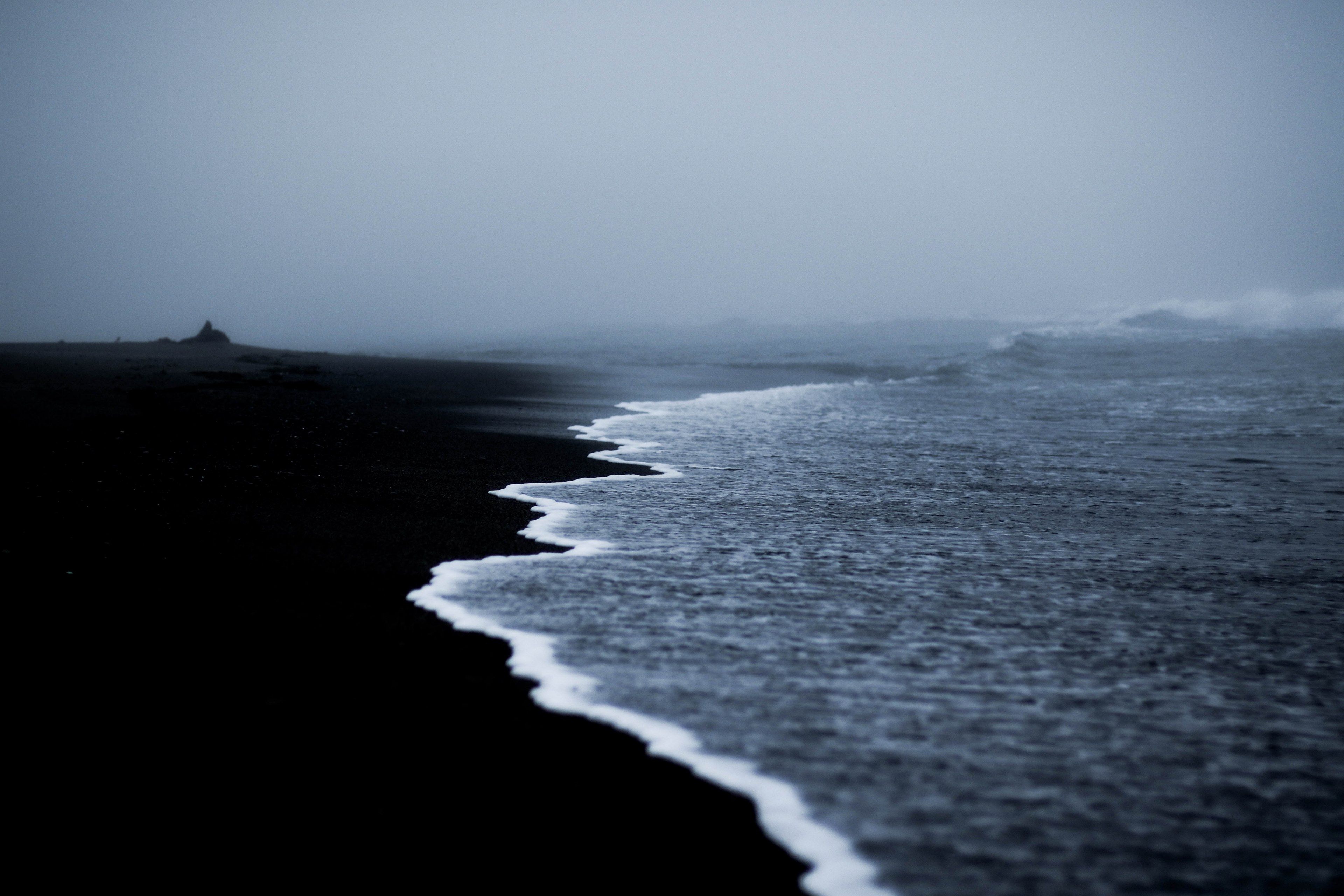 Wallpaper / ocean waves washing on the black sand beach at trestles beach, separating lines 4k wallpaper