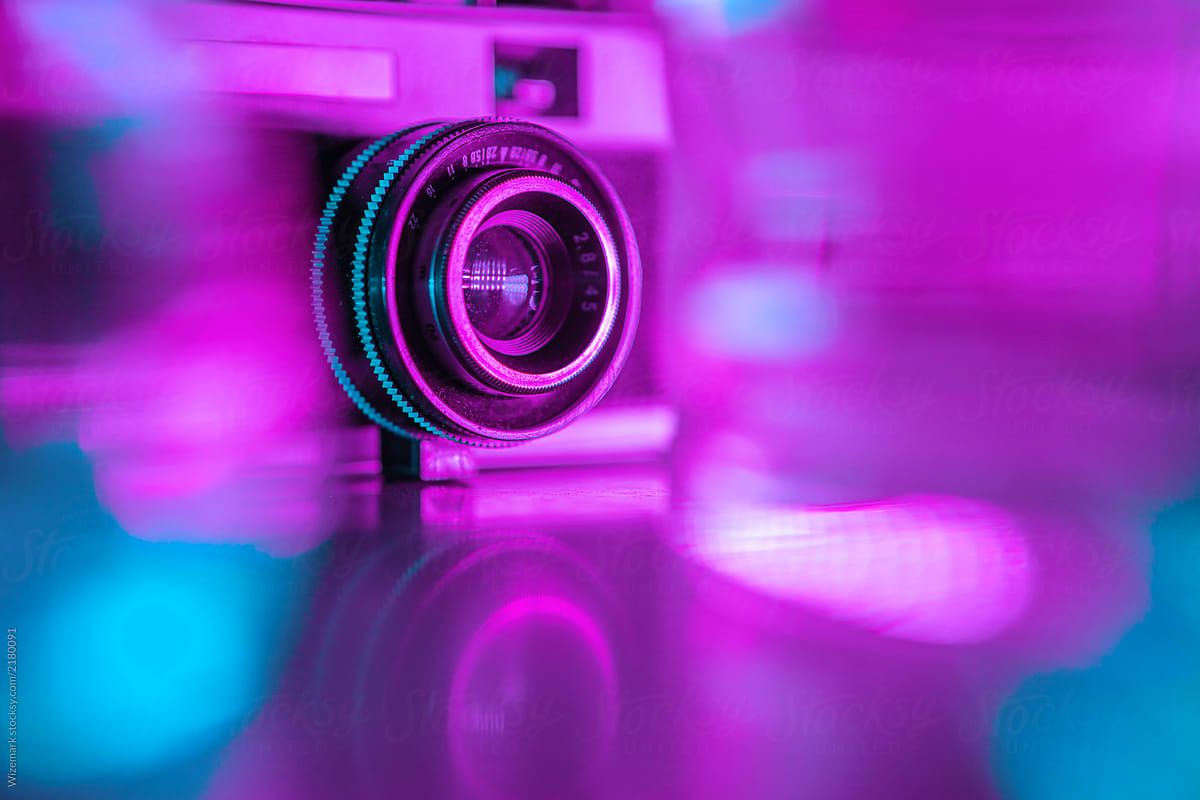 Old retro camera under colorful neon lights by Wizemark, Modern