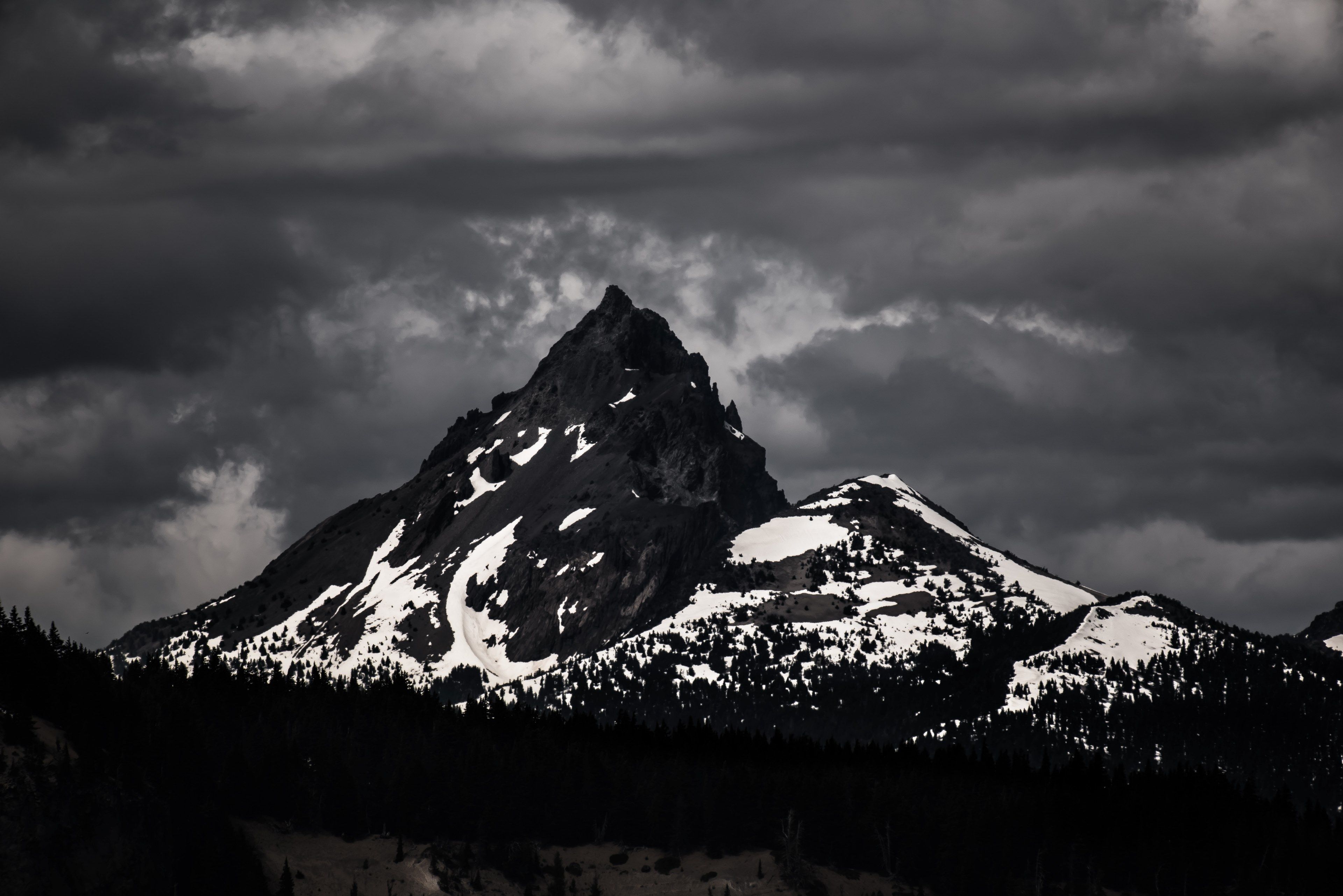Wallpaper / a desaturated shot of a dark mountain covered in patches of white snow under a gray sky, diamond peak in sepia 4k wallpaper