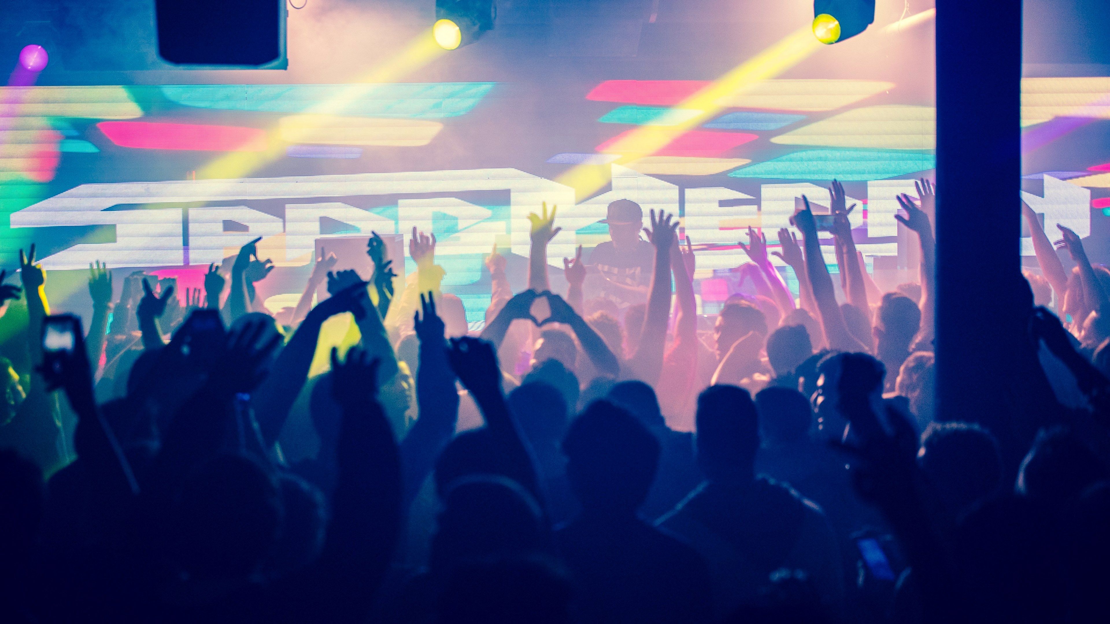 Wallpaper / crowd with raised arms in a colorful club in silhouette, spag heddy 4k wallpaper