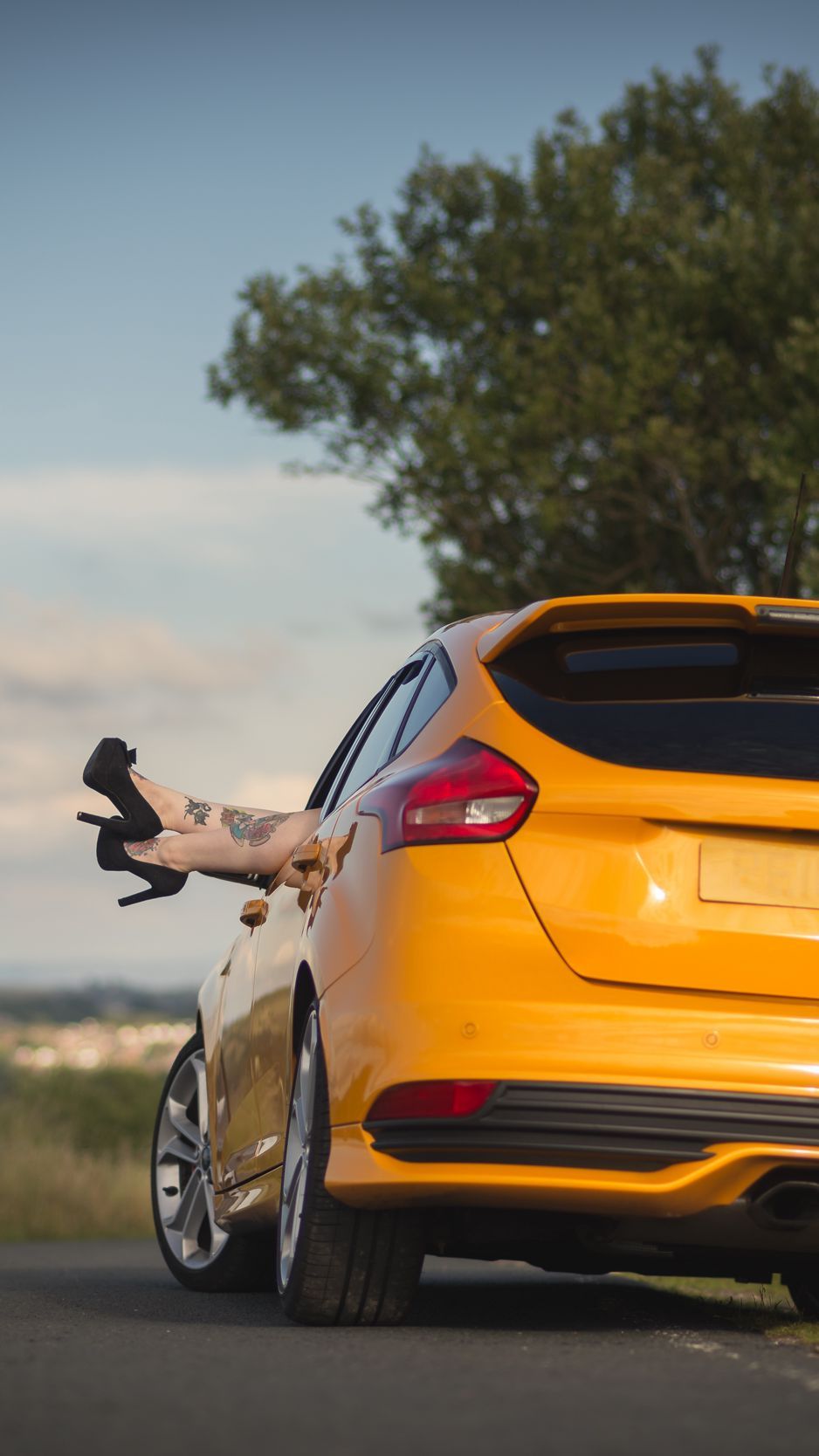 Download Wallpaper 938x1668 Ford, Car, Legs, Shoes, High Heeled Shoes, Tattoos, Girl, Rest, Nature, Ford Focus St Iphone 8 7 6s 6 For Parallax HD Background
