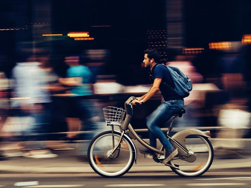 Man Riding Bicycle on City Street HD Wallpaper