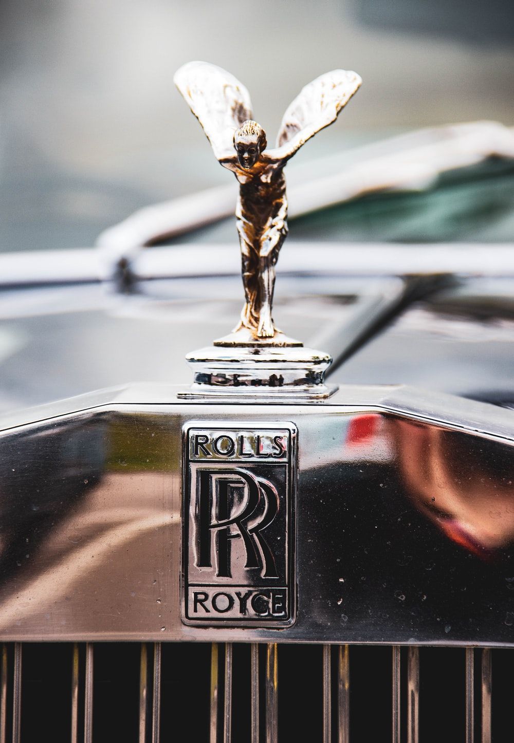 Close Up Photography Of Silver Rolls Royce Emblem Photo