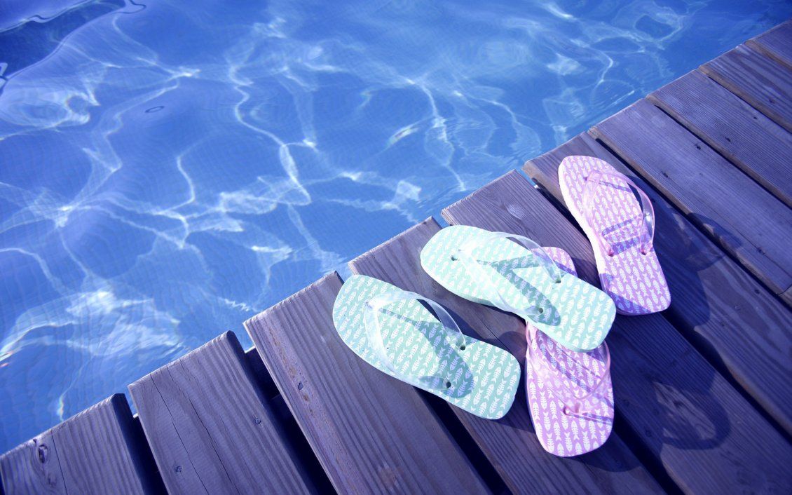 Blue and pink flip flop near the pool