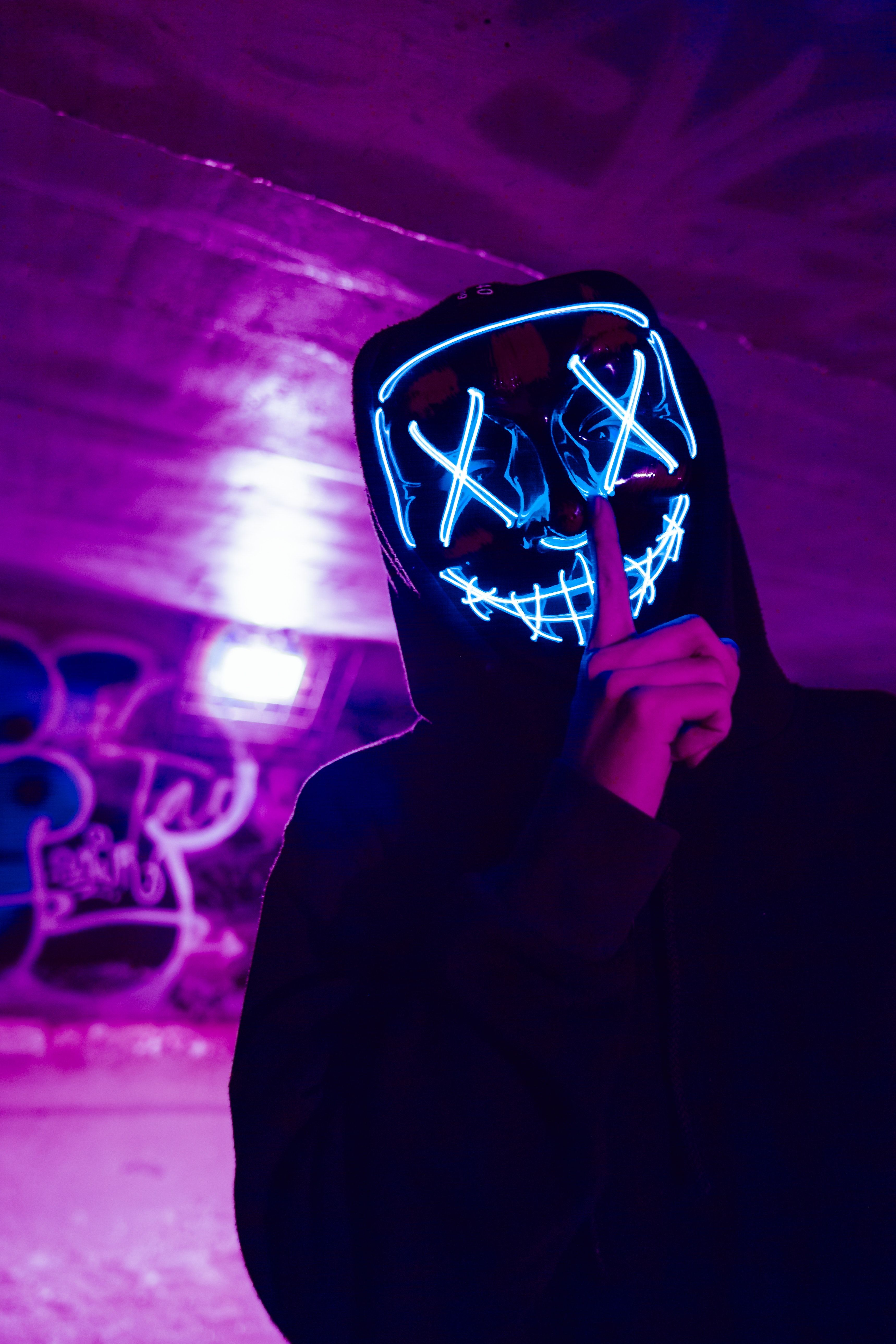 Person Wearing LED Mask Doing Silence Gesture · Free