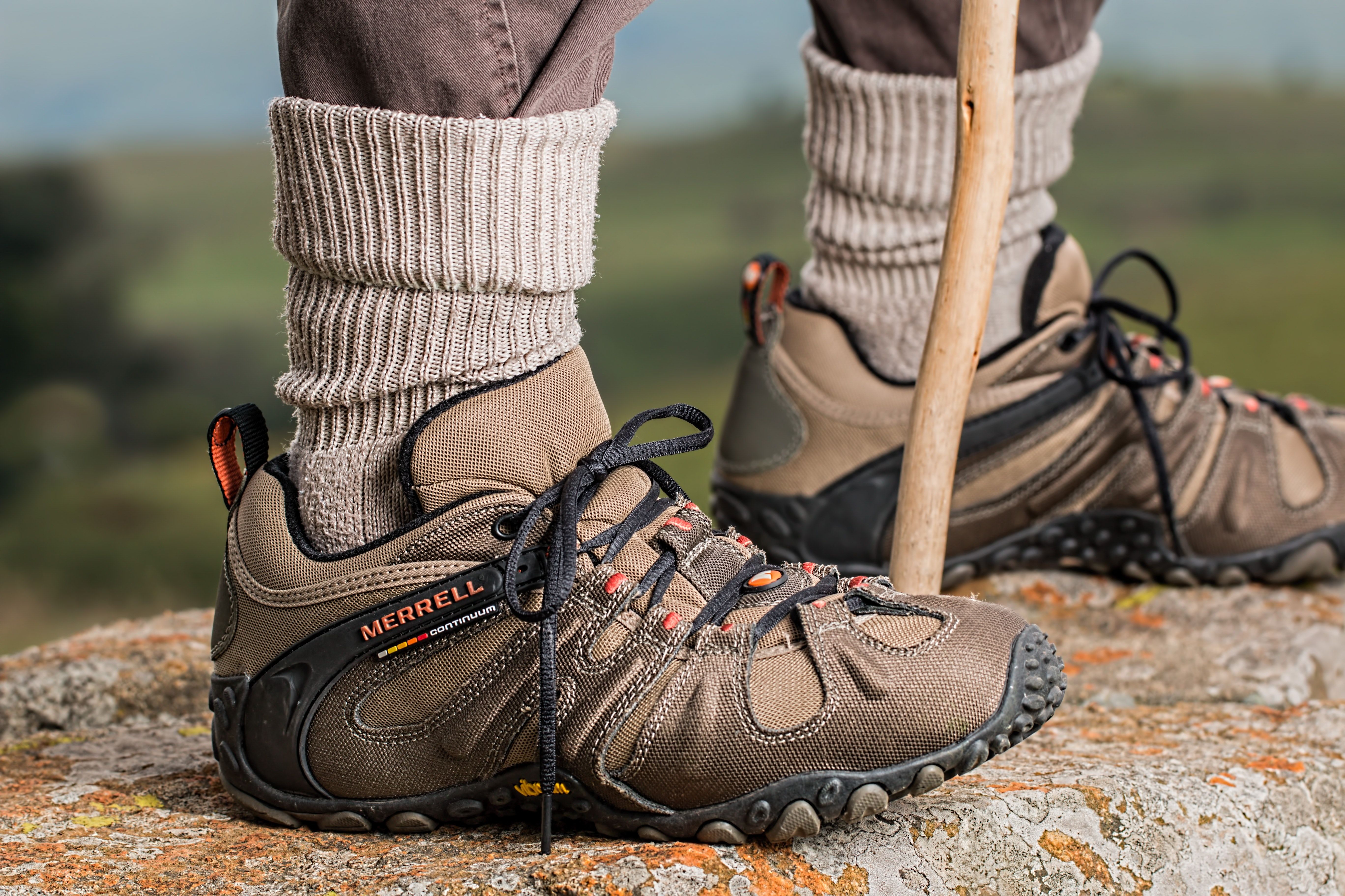 Men's Brown and Gray Merrell Hiking Shoes Holding Stick · Free