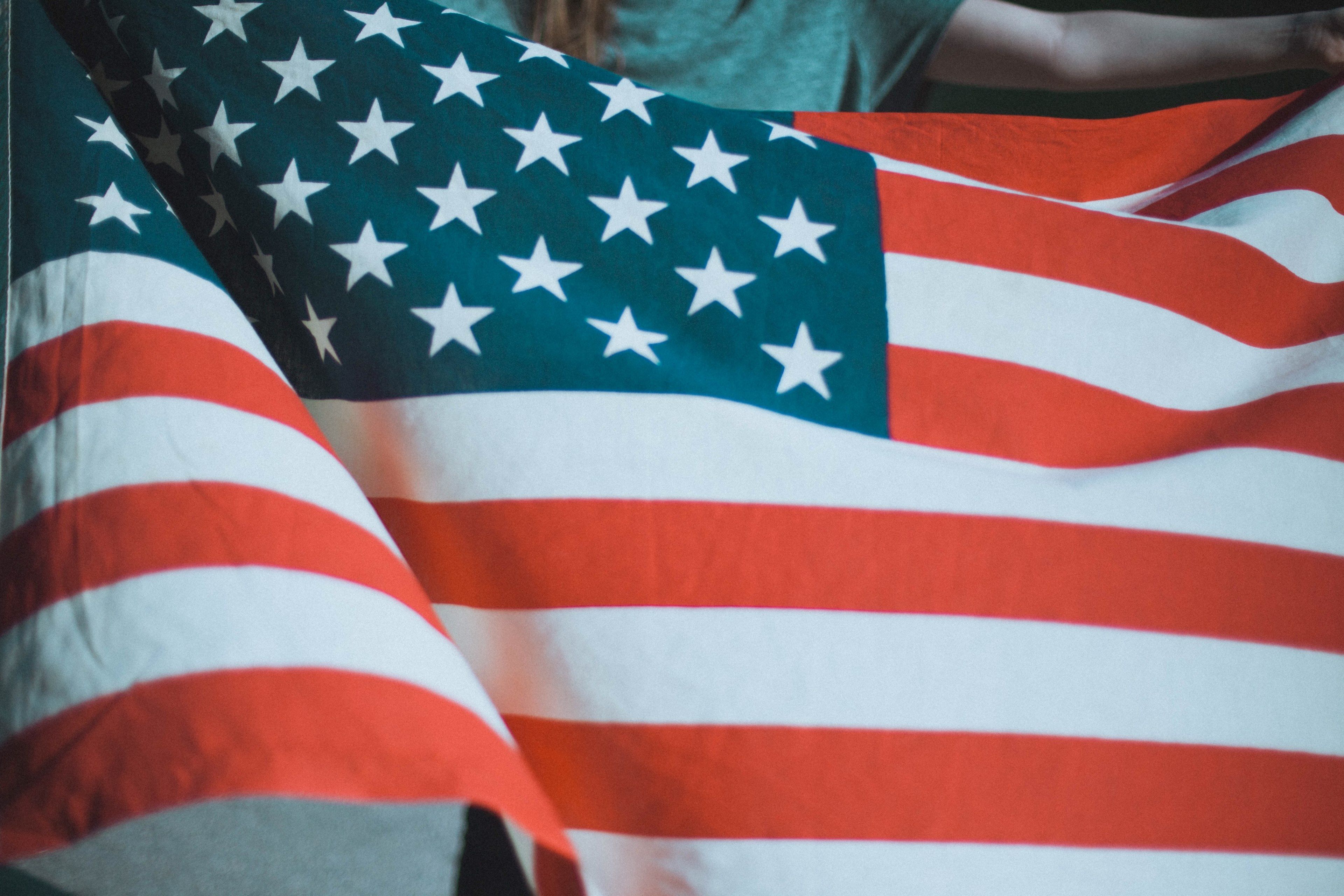Wallpaper / a person holding an american flag, person holding american flag 4k wallpaper