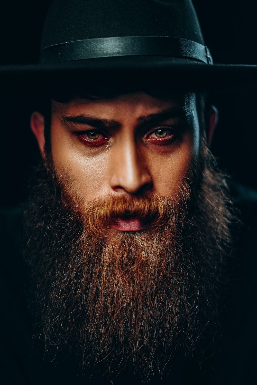 man with black beard wearing black hat photo