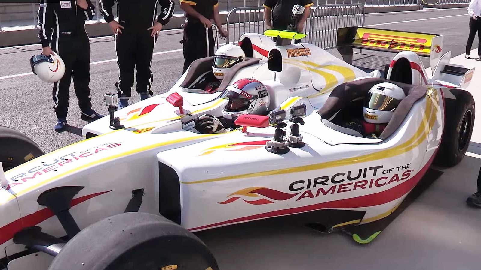 Playmate rides in F1 car with Mario Andretti