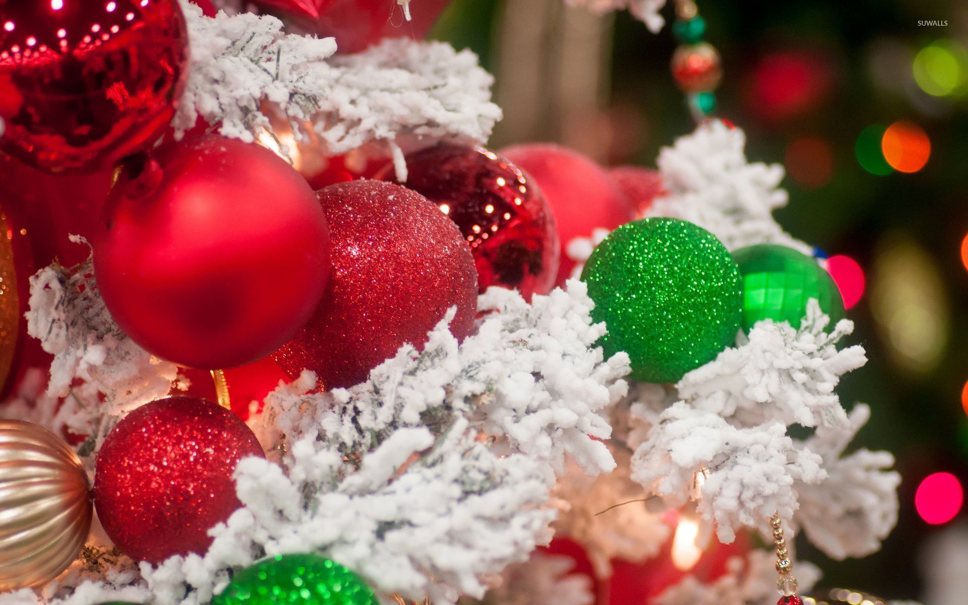 Sparkly red and green baubles on the snowy Christmas tree wallpaper wallpaper