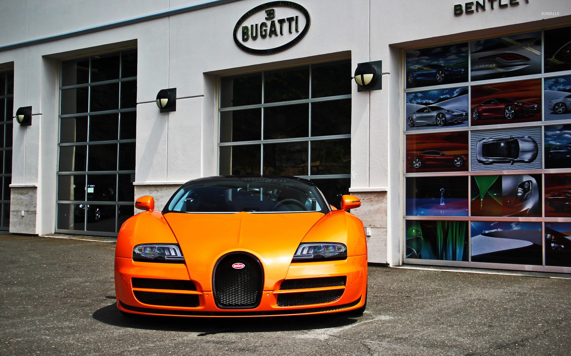 Orange Bugatti Veyron parked in front of a showroom wallpaper wallpaper
