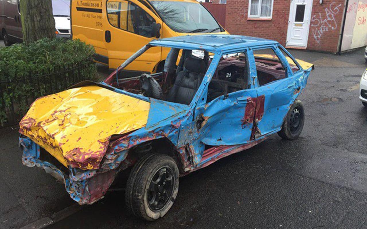 Police pull over battered car being driven on the roads without any windows or mirrors