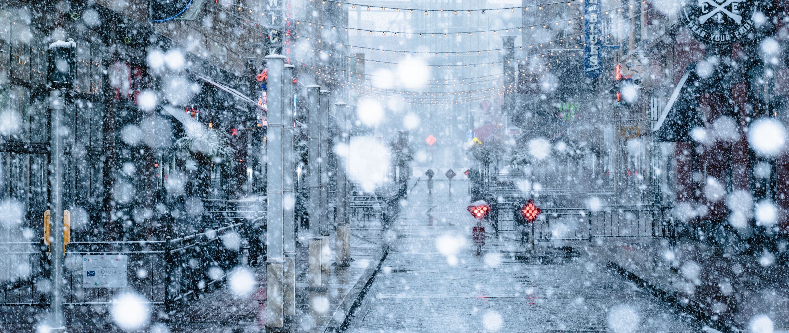 Download wallpaper 2560x1080 snowfall, snow, street, city, winter dual wide 1080p HD background