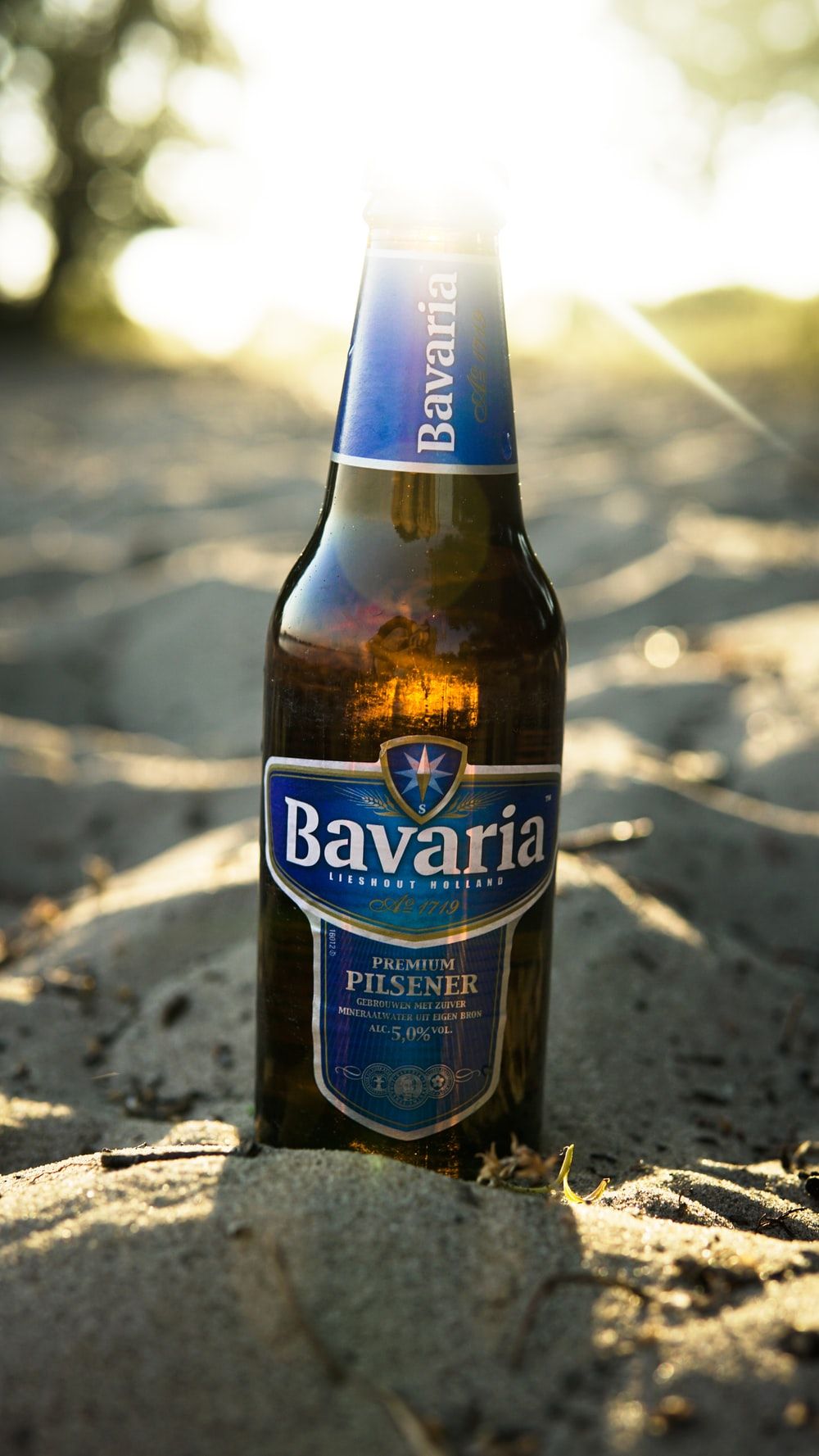 Bavaria Pilsener beer bottle on sand photo