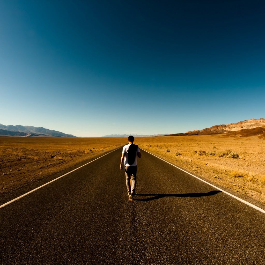man walking alone on road