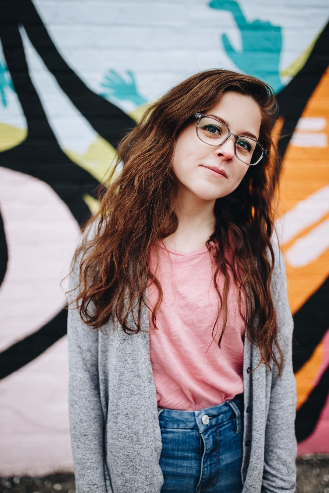 girl wearing eyeglasses with silver frames behind graffiti photo