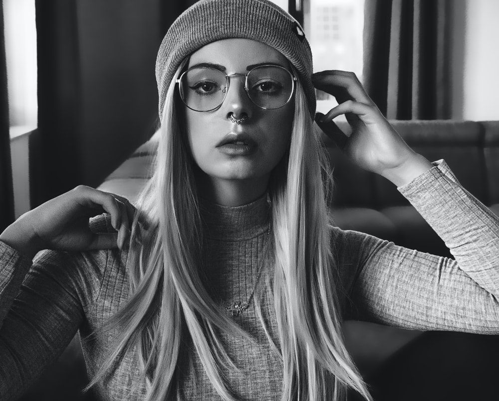 grayscale photo of woman wearing knit cap and eyeglasses photo