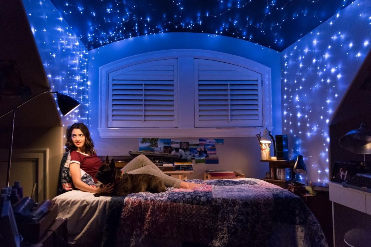 Kat (played by Laura Marano) sits under the stars with her dog Bruno (played by Capone)