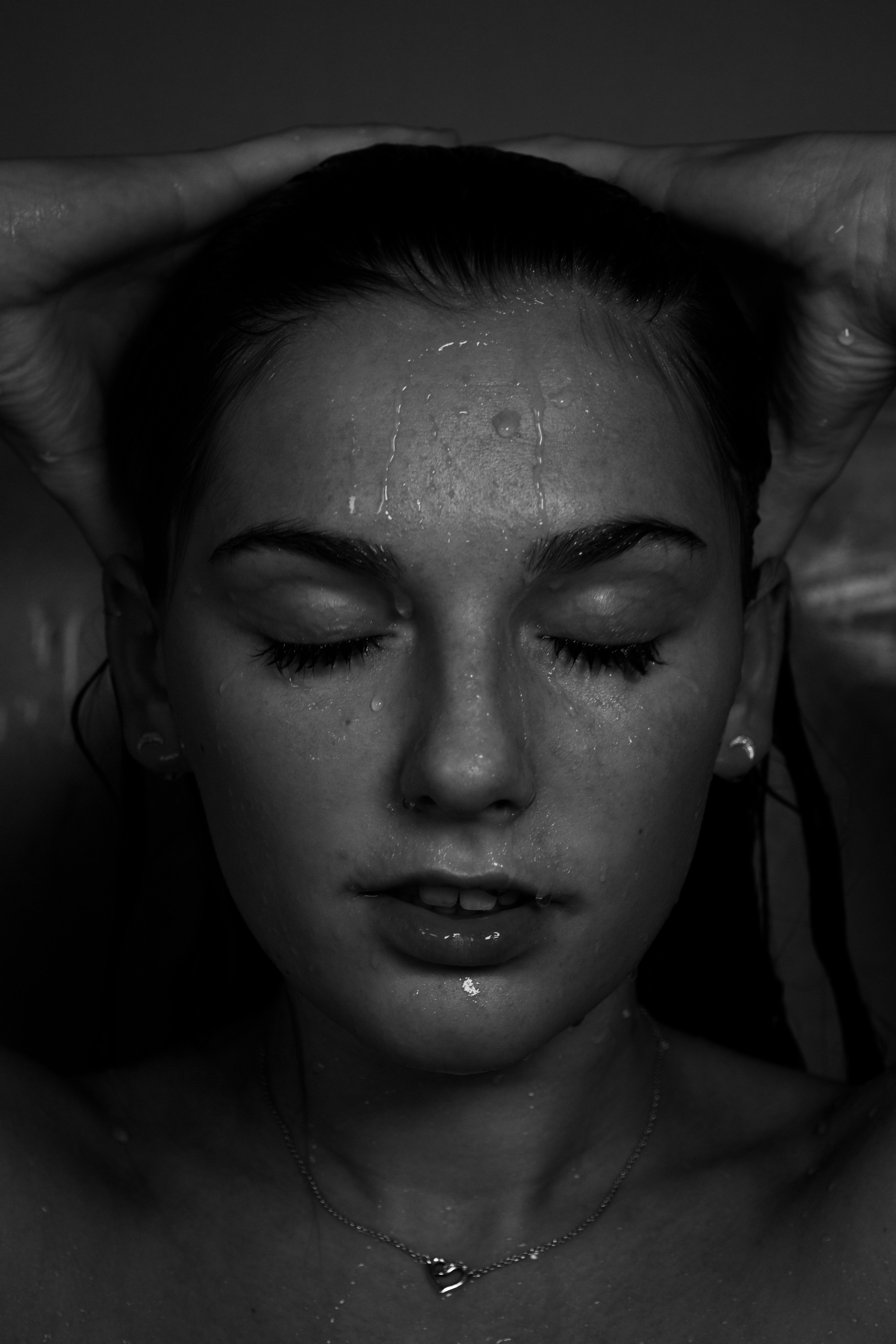grayscale photography of topless woman with water drops on face photo