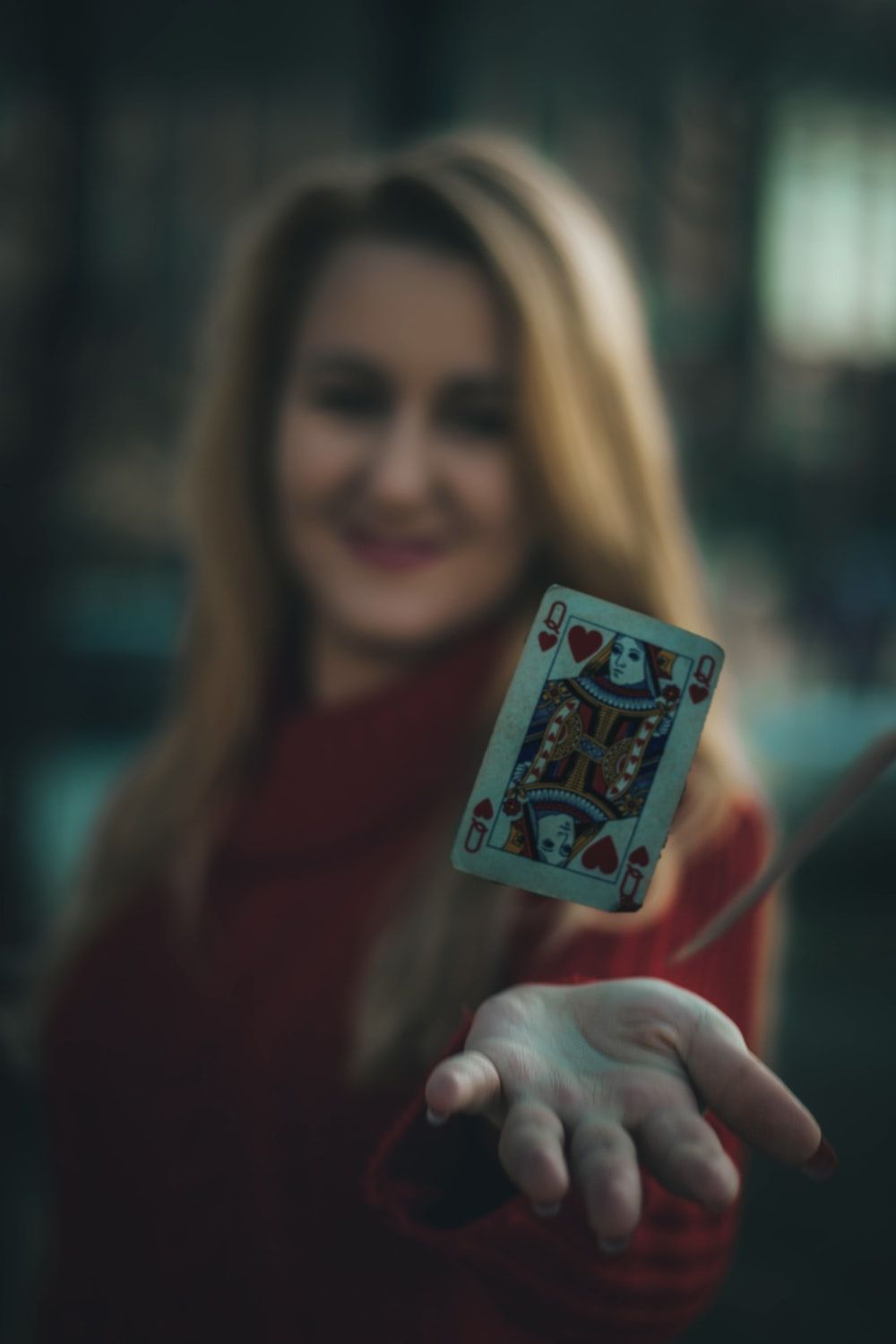 time lapse photo of queen of hearts playing card near woman's palm photo