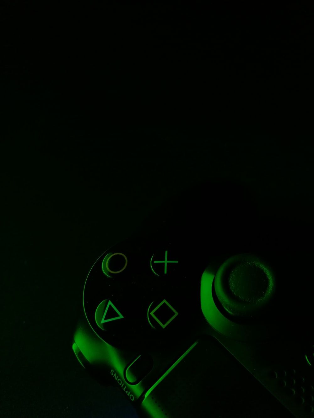 green and black game controller in dimmed light photo