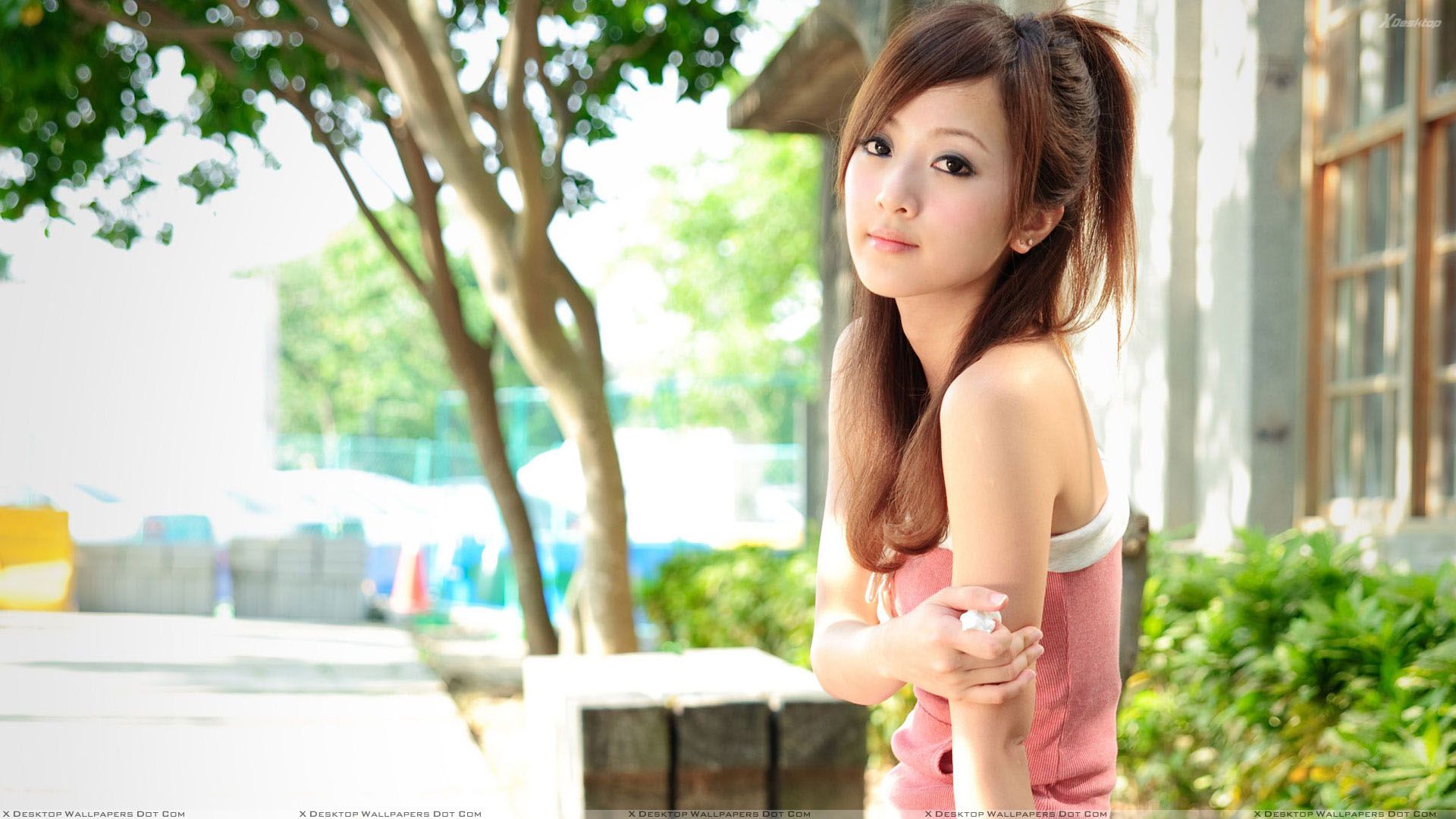 Asian Model Smiling In Pink Top Side Pose Wallpaper