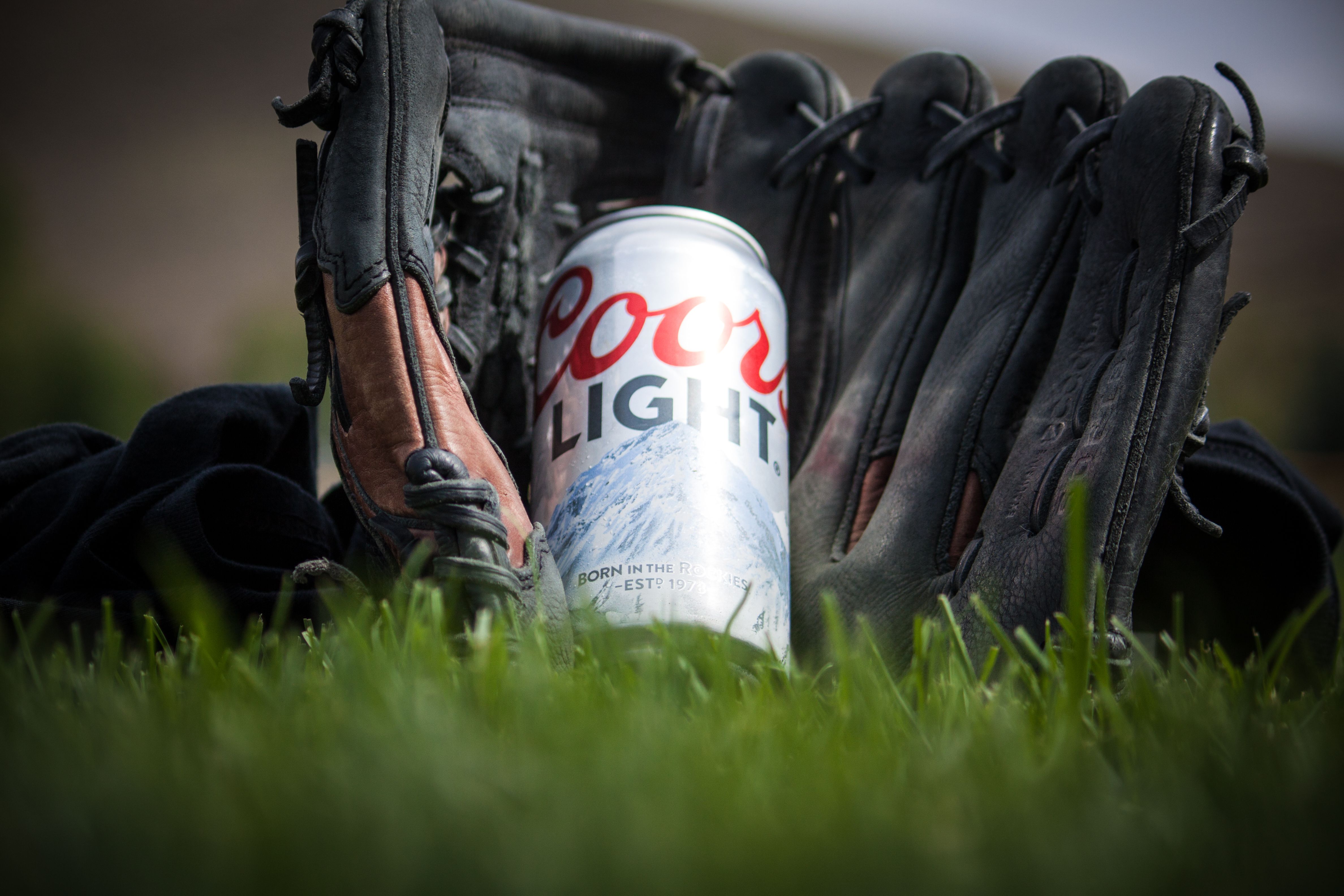 Close Up Photography of Coors Light Beer Near Black Baseball Mitts · Free