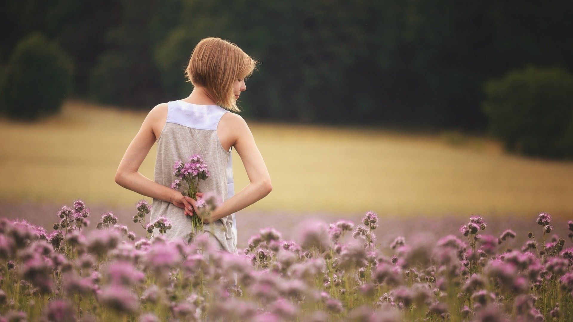 Girl With Flowers Standing In Field Wallpaper