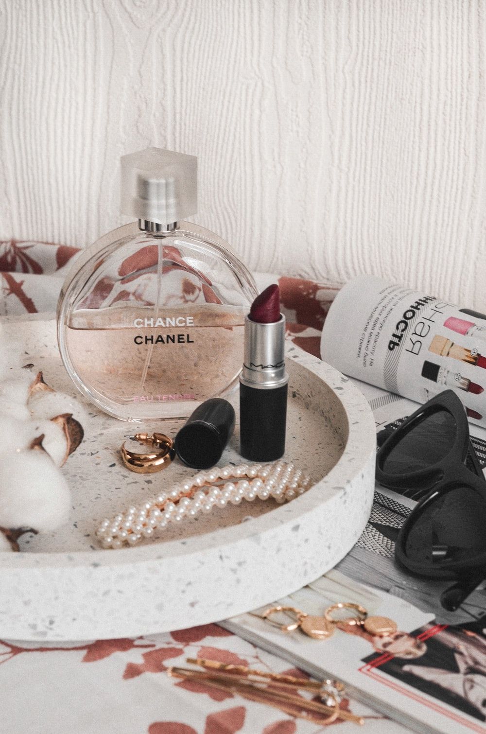 Chanel perfume bottle beside maroon lipstick photo