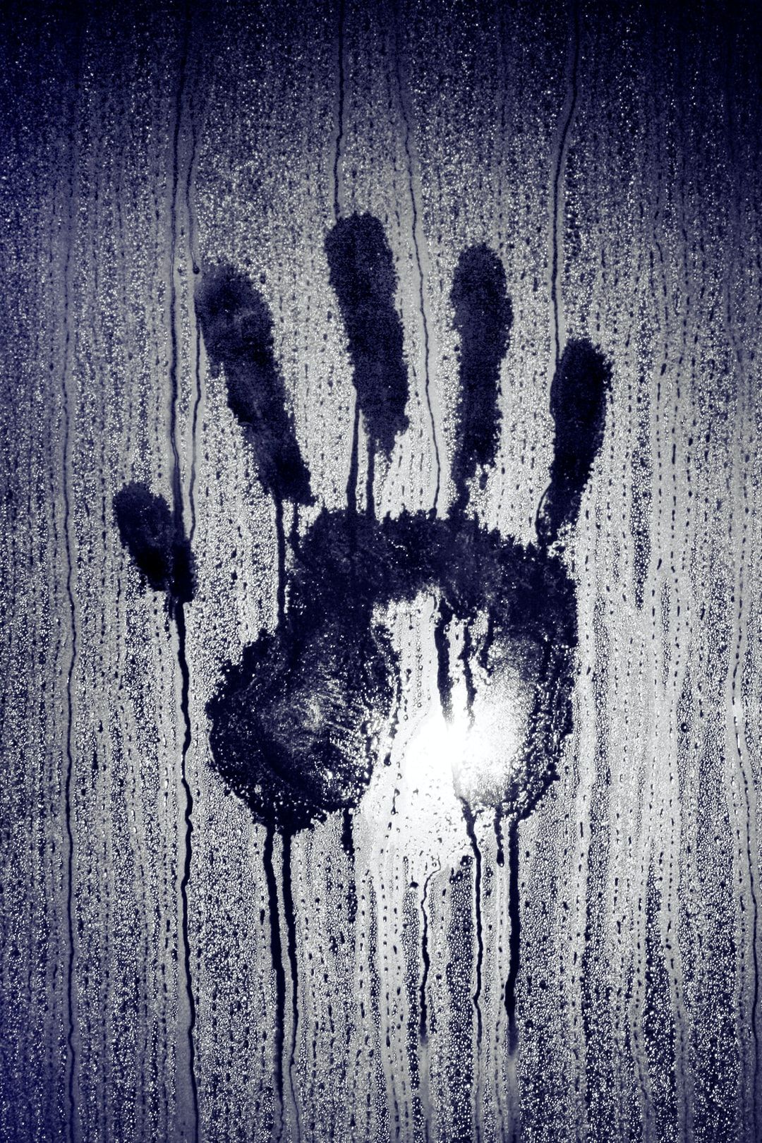 person's hand print on moistened glass photo