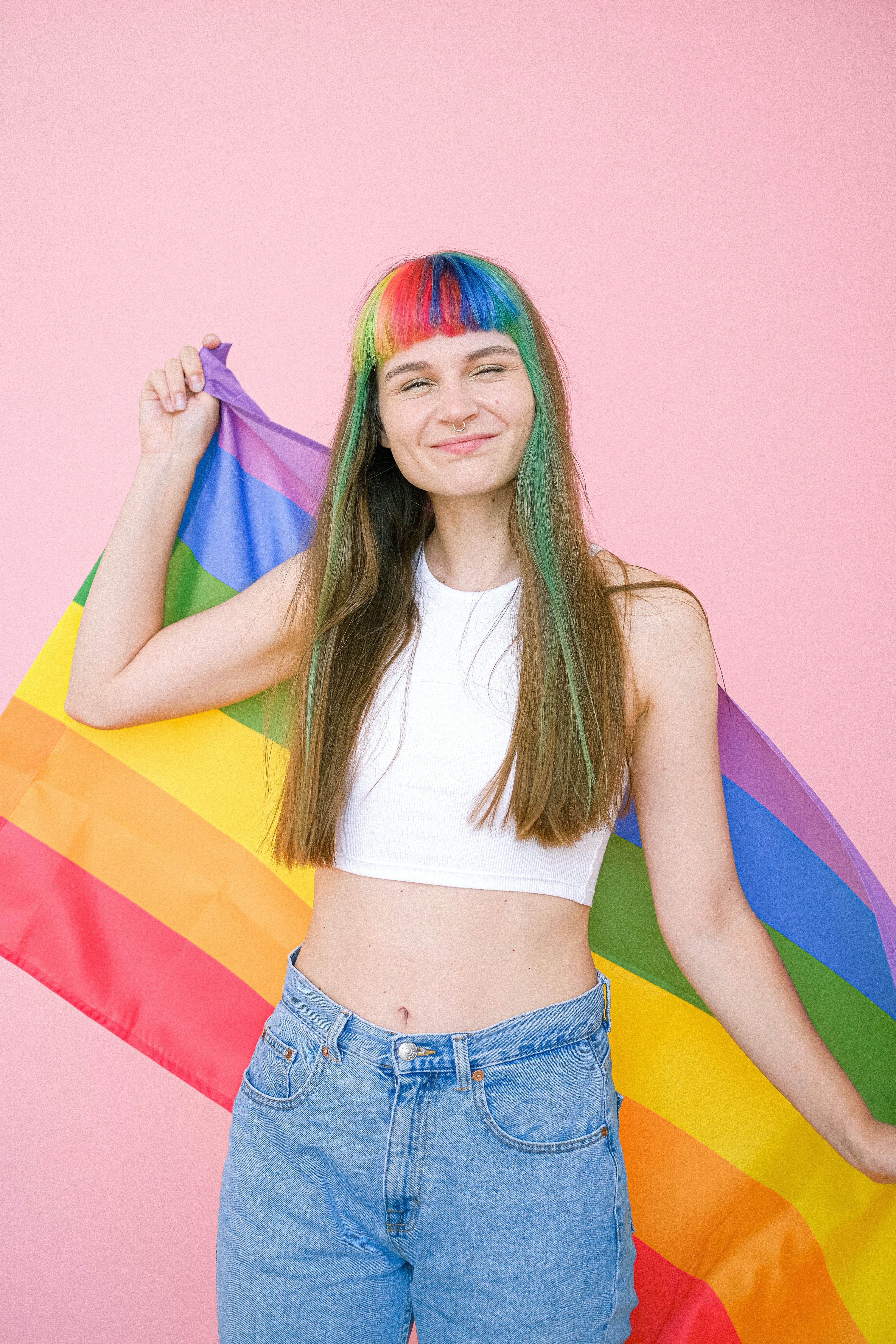 Woman in White Tank Top Holding a Gay Pride Flag · Free
