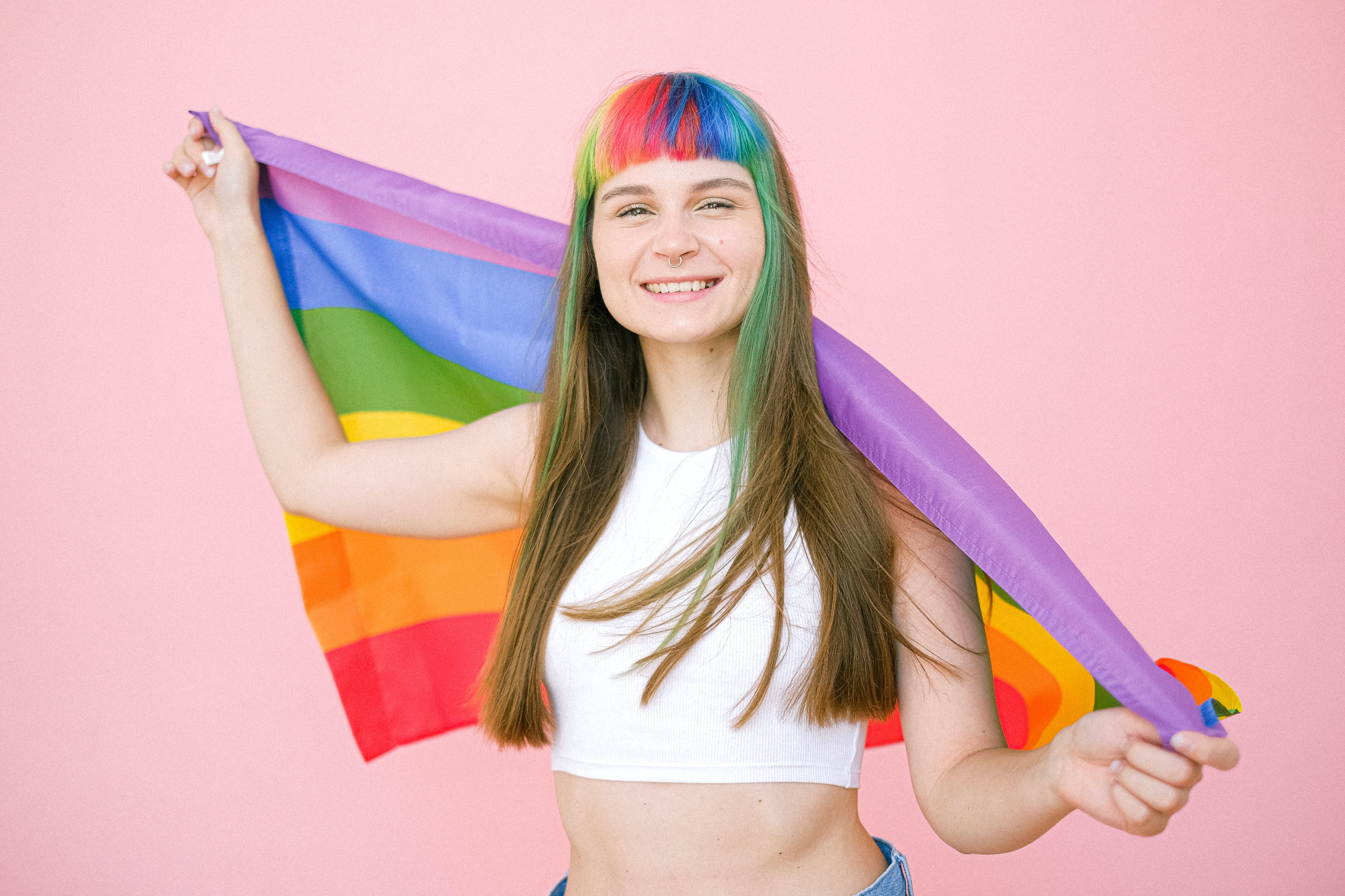 Smiling Woman Holding a Gay Pride Flag · Free
