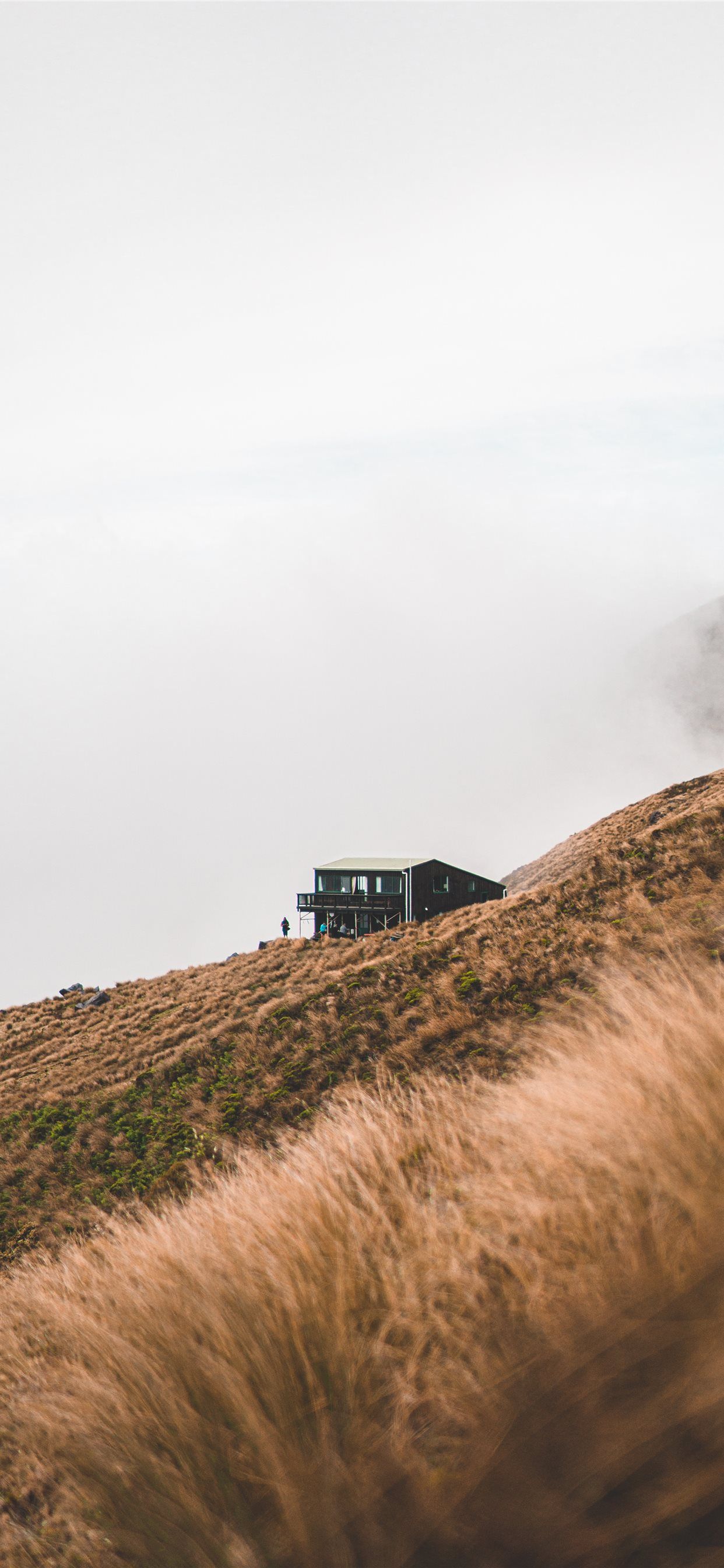 black house on brown grass field under white cloud. iPhone 11 Wallpaper Free Download