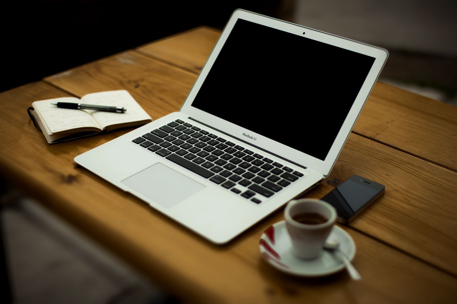 Premium Photo | Open laptop computer with coffee cup and notebook on white  table and blank wall background