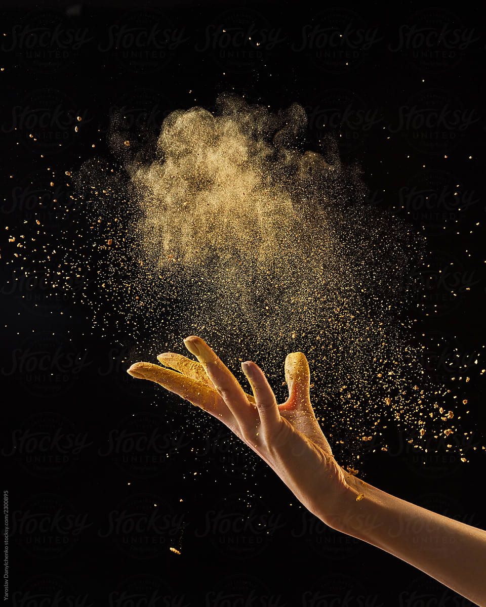 photo of female hand throwing gold dust .stocksy.com