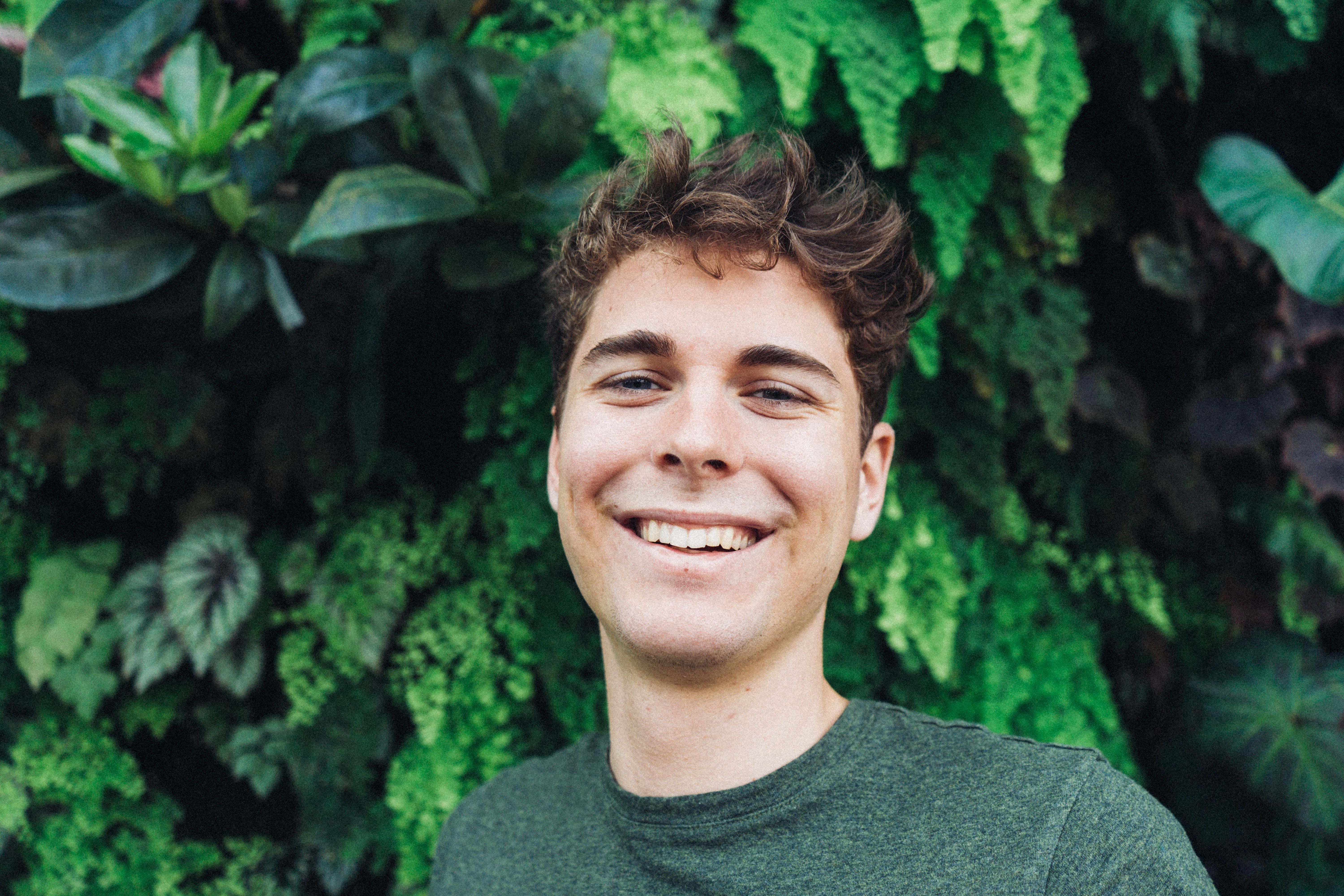 Smiling Man in Front of Green Plants .pexels.com