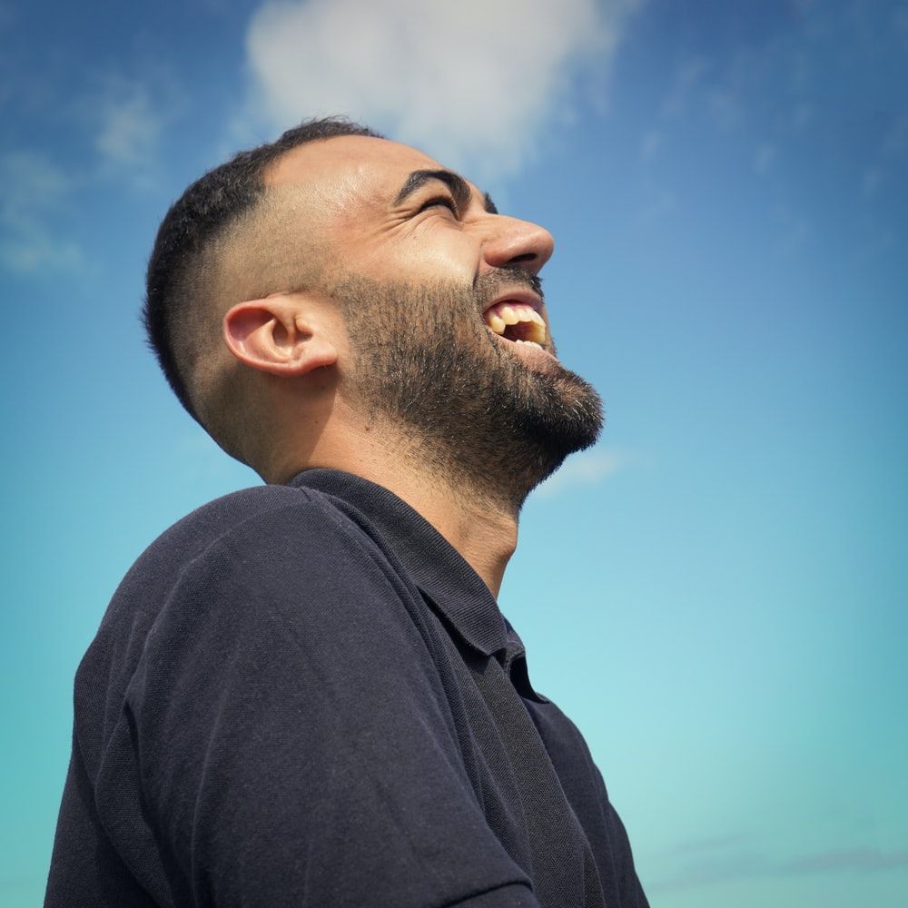 smiling man wearing black collared top .com