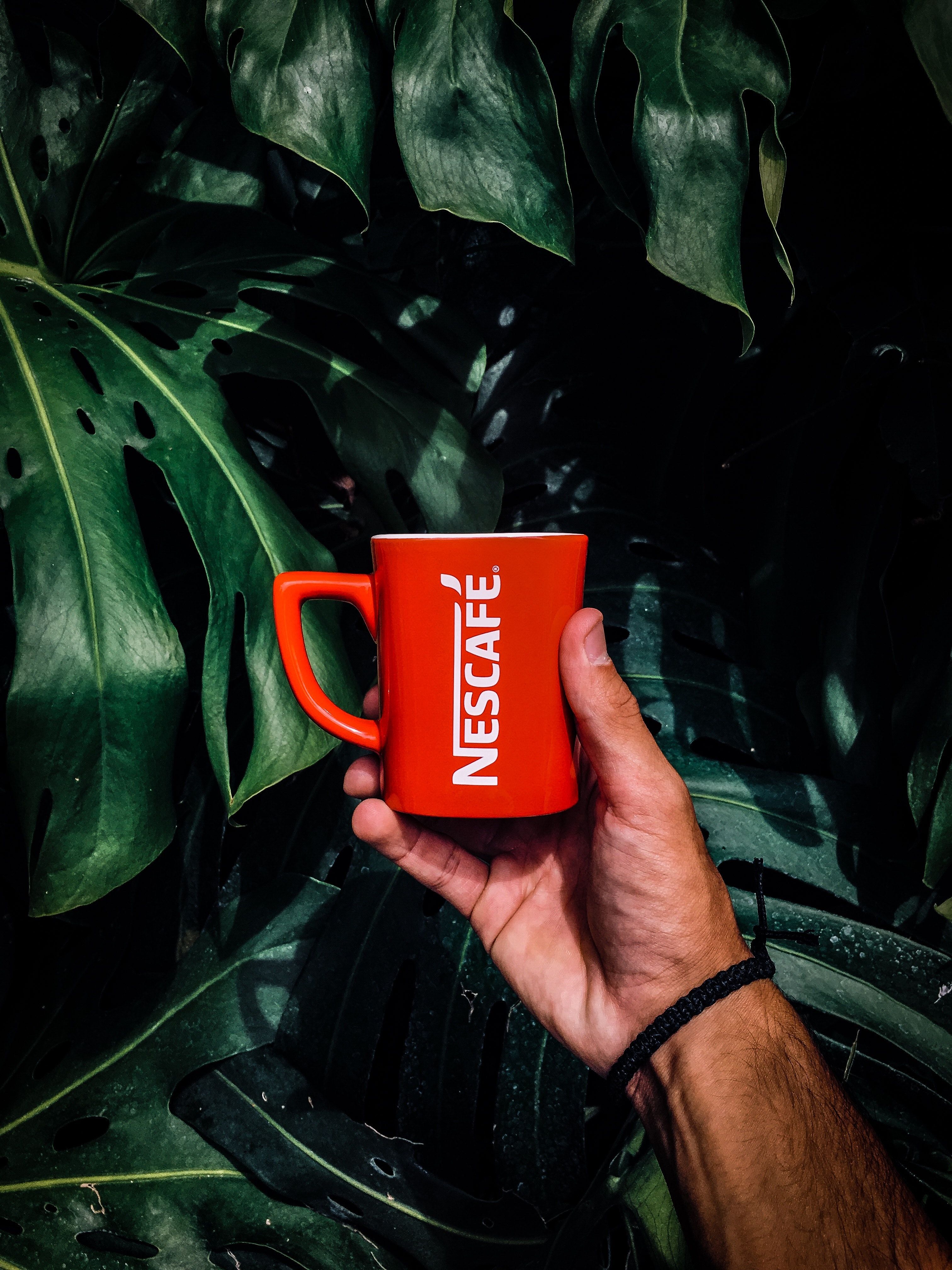 Photo of Man Holding a Red Nescafe Mug .pexels.com