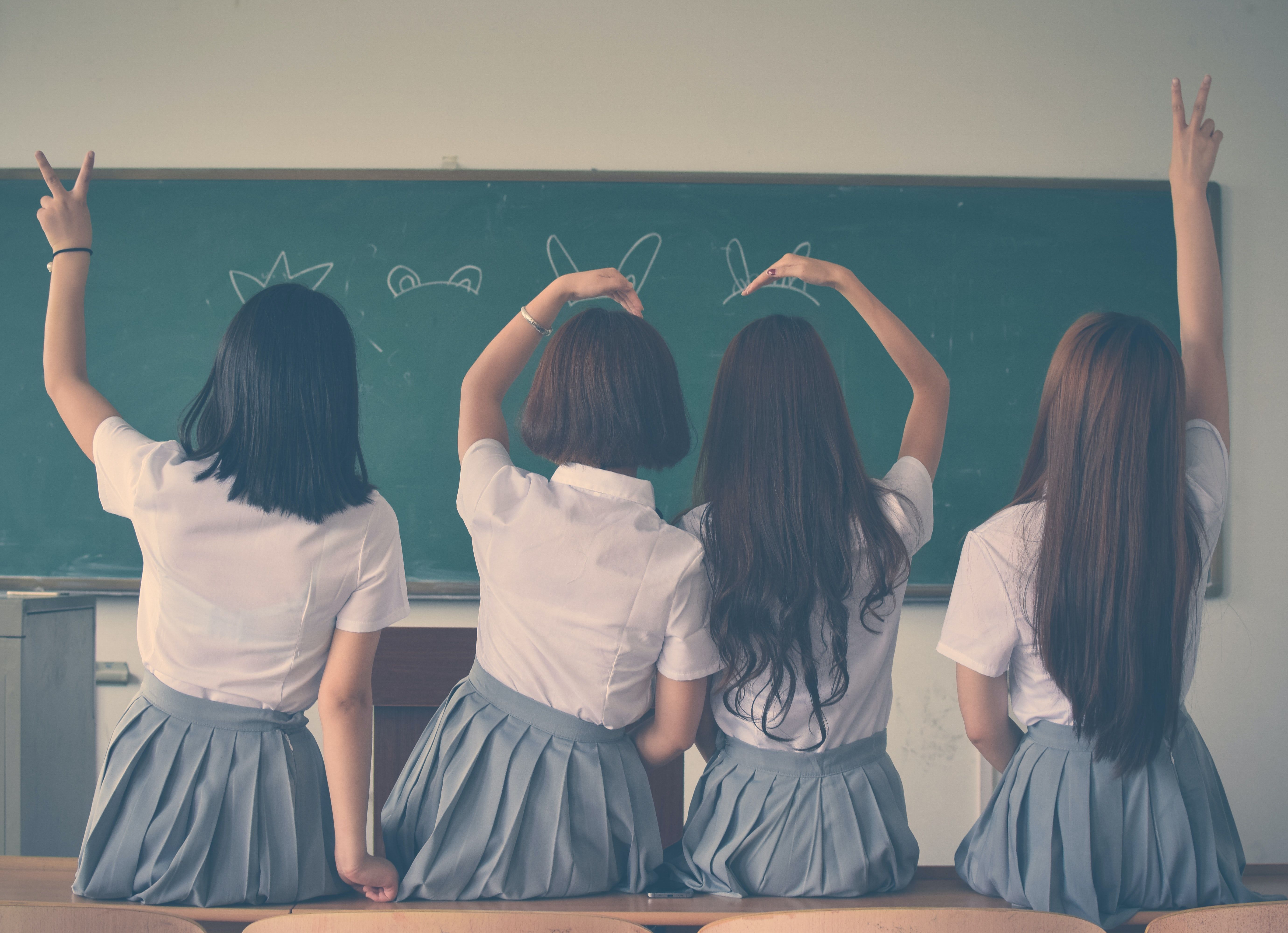 Photo of Four Girls Wearing School Uniform Doing Hand Signs · Free