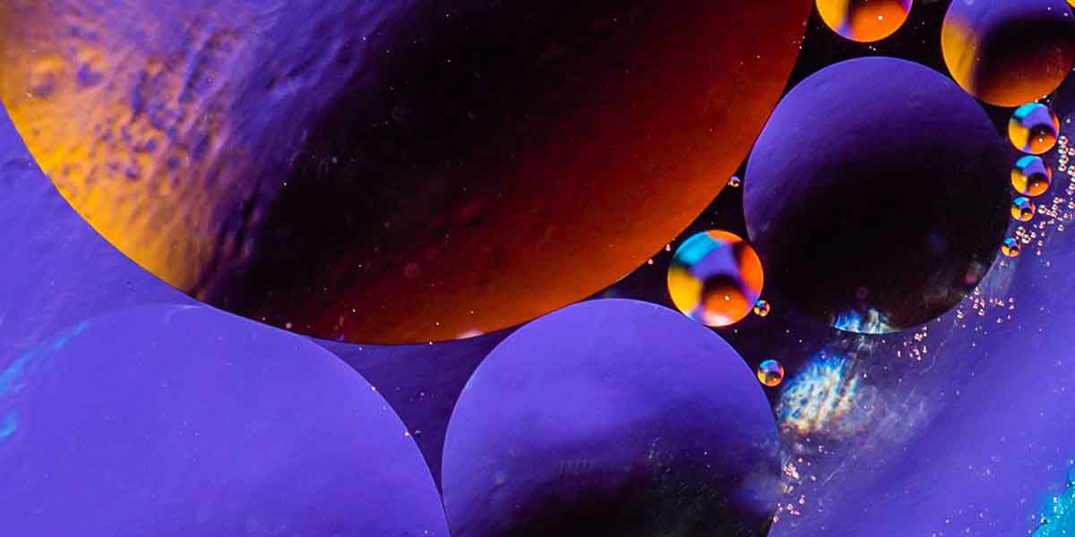 Macro shot of oil bubbles with water on colorful background. Space and universe planets styled abstract image Ahmad Bin Hezeem & Associates LLP