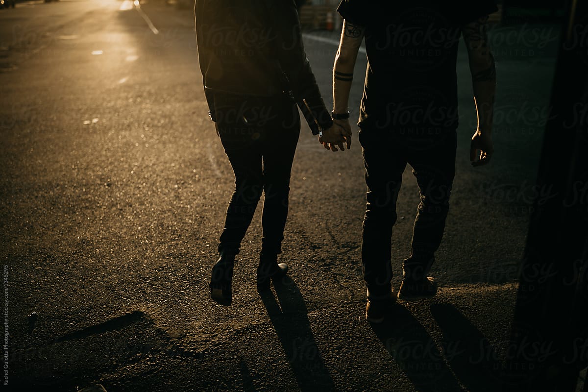 Couple Holding Hands Walking into Sunset by Mango Street Lab