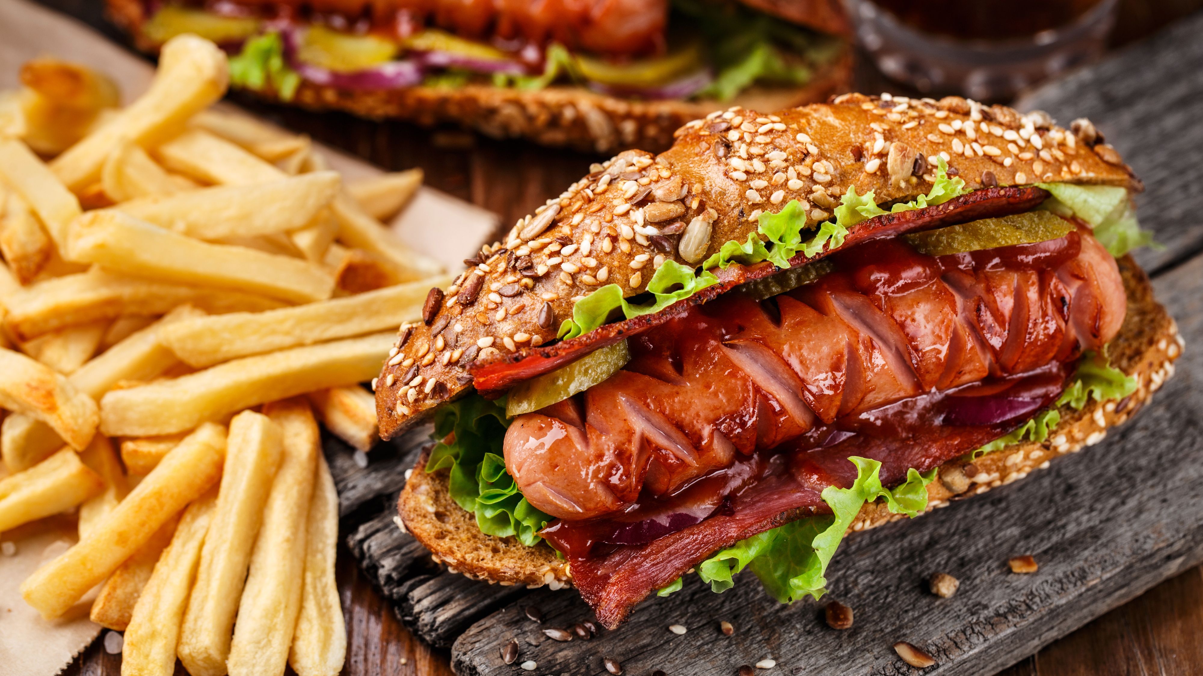 Hotdog with sausage and bacon on the table with french fries wallpaper and image, picture, photo