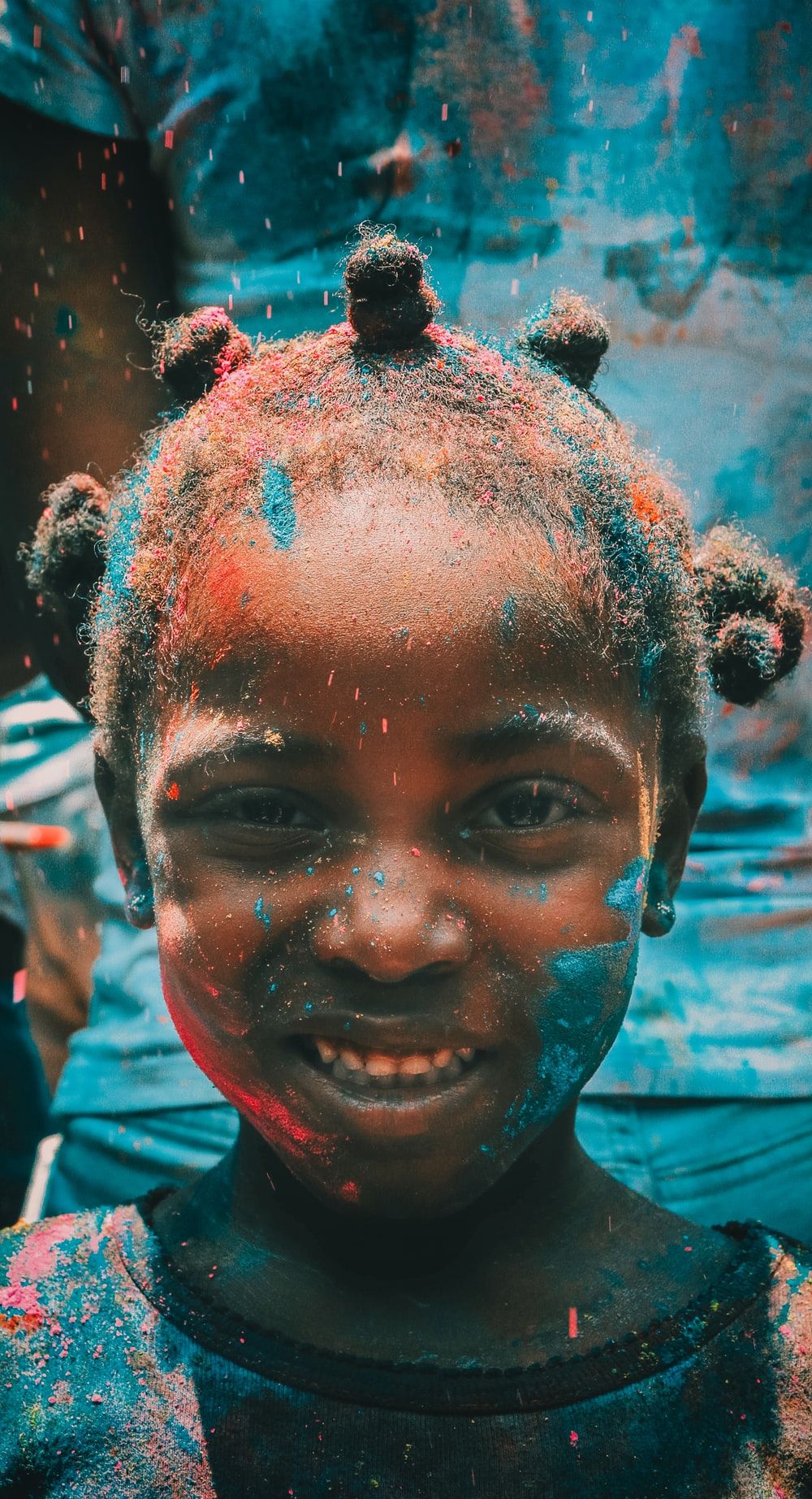 girl covered with holi powder during daytime photo