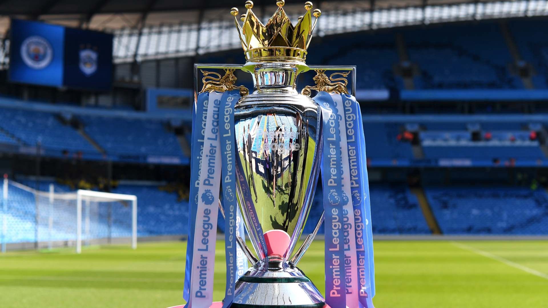  The Premier League trophy sits on the pitch inside an empty stadium.