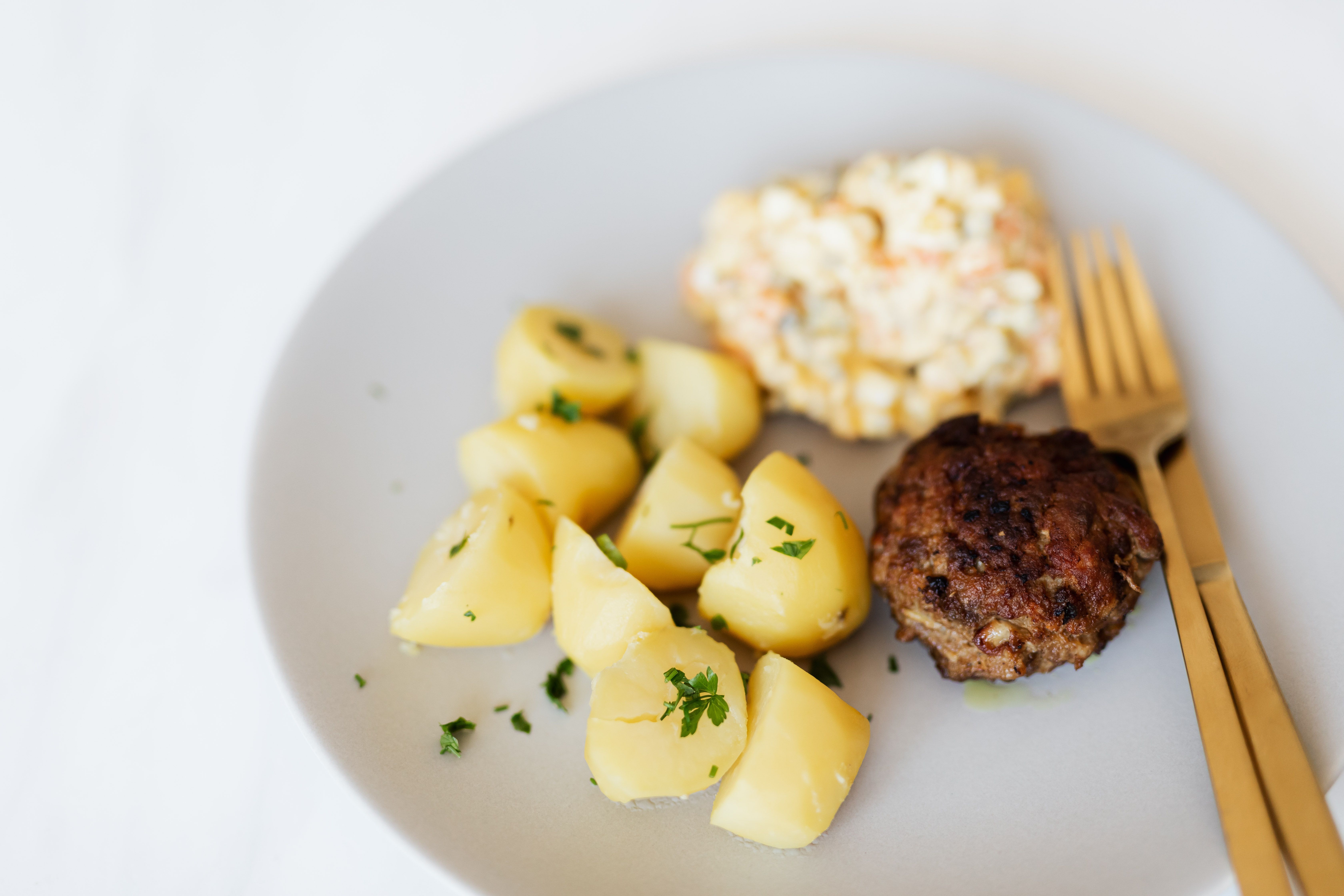 Fried meat cutlet served with boiled potatoes and salad · Free