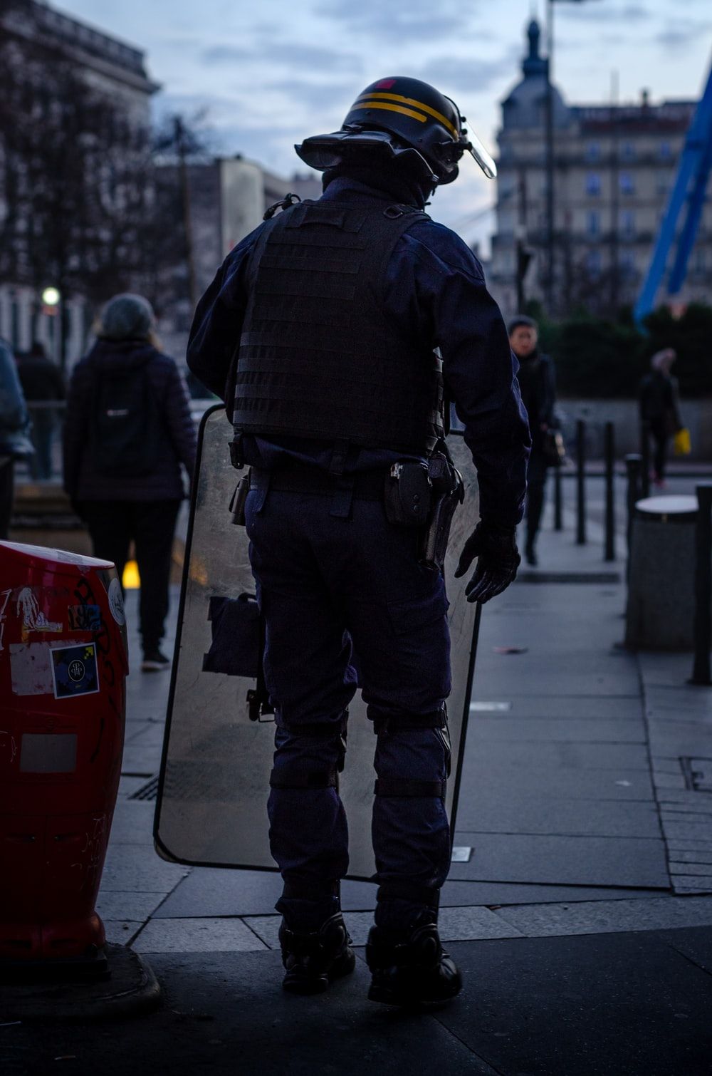 police officer standing and carrying riot shield photo